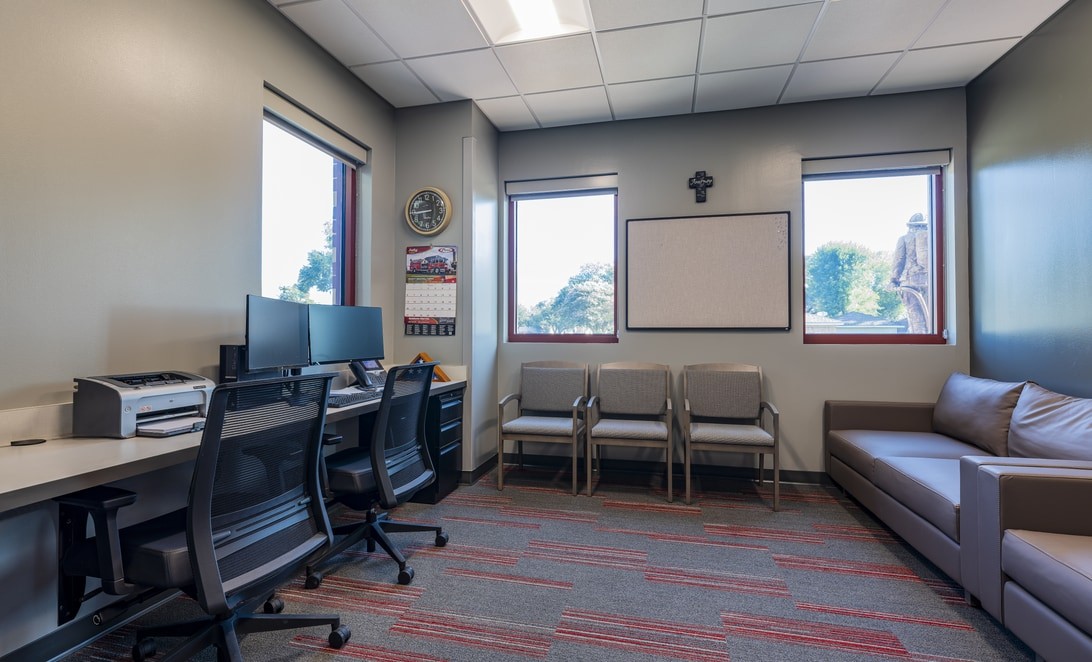 Watch office with desk workstations and a seating area at City of Deer Park Fire Station 2, by Martinez Architects