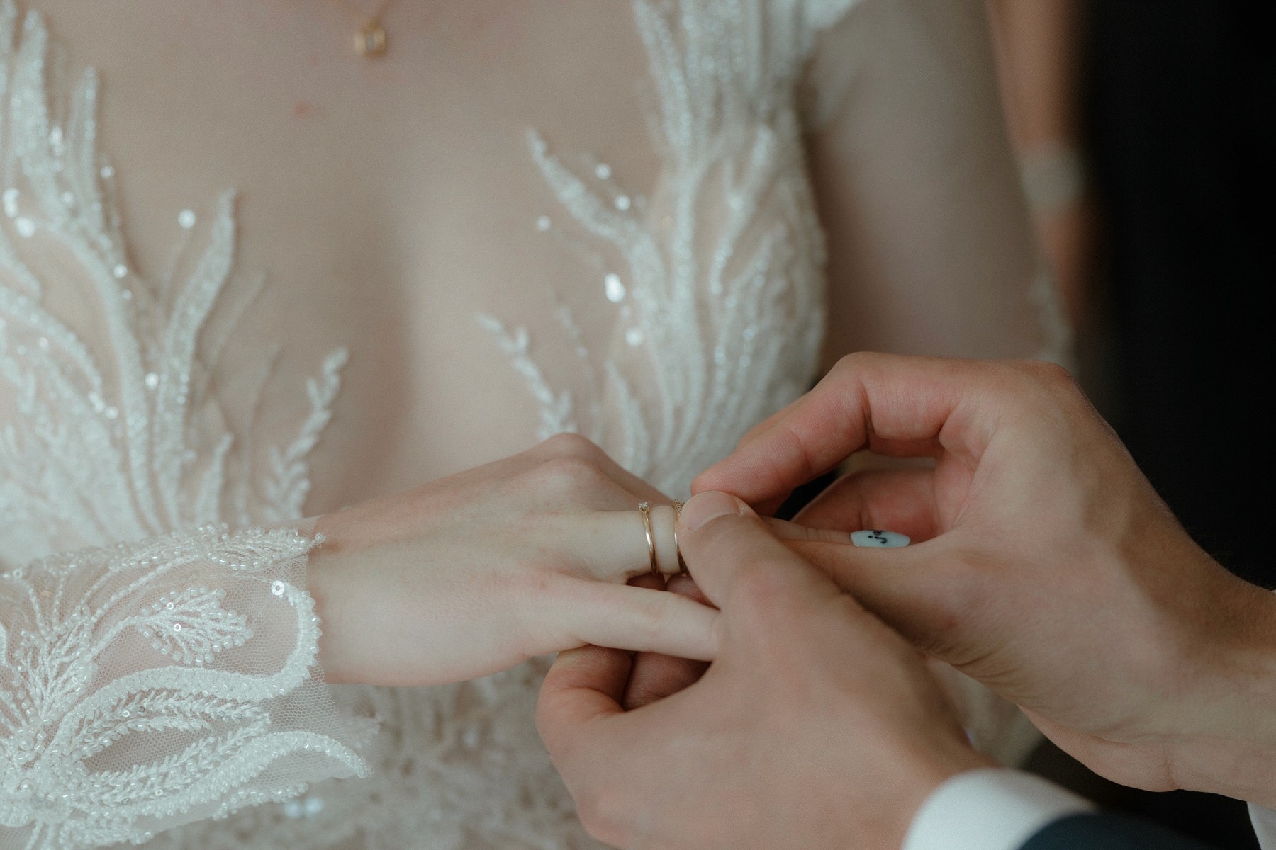 closeup of wedding ring exchange hands