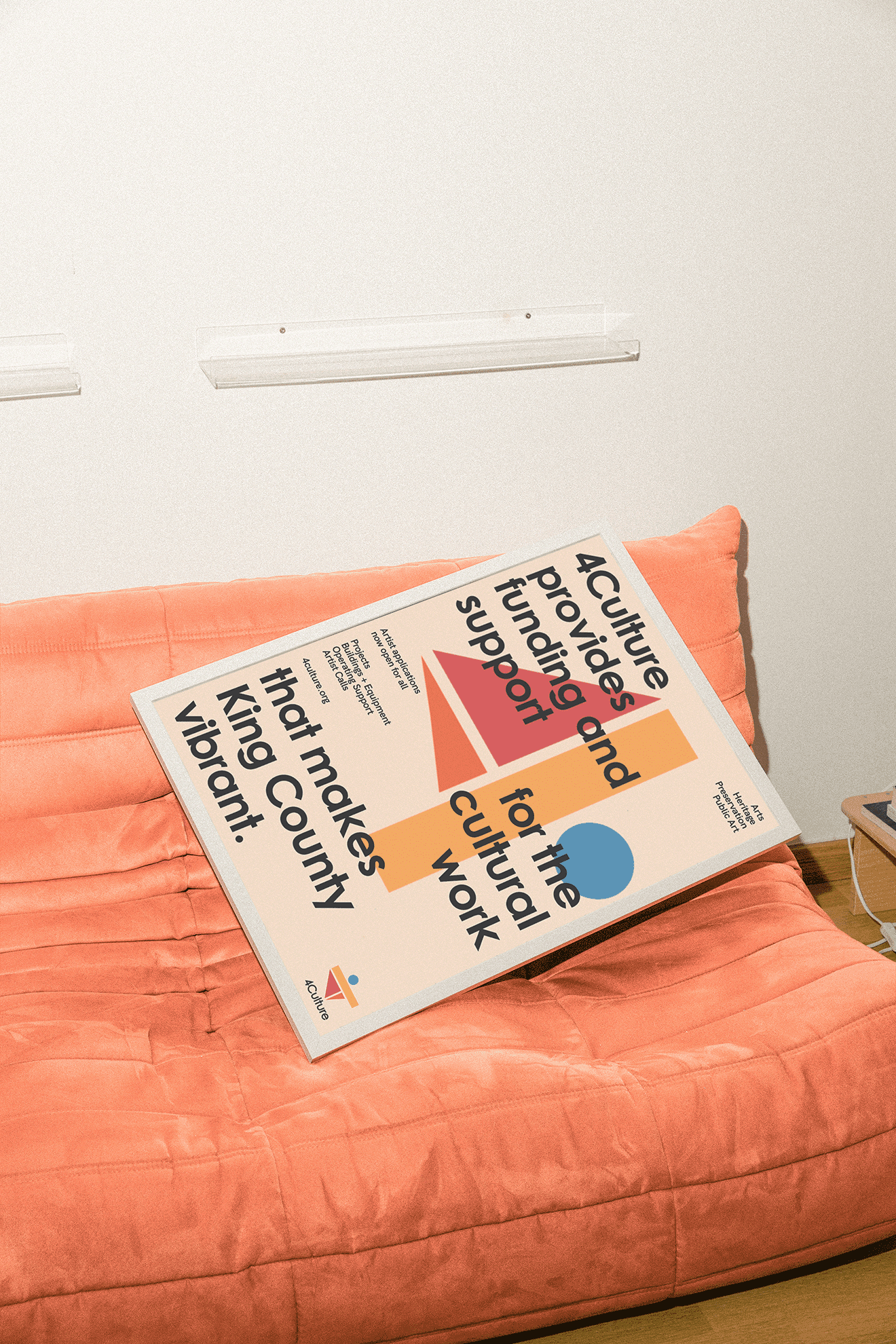 A colorful poster laying across a orange couch