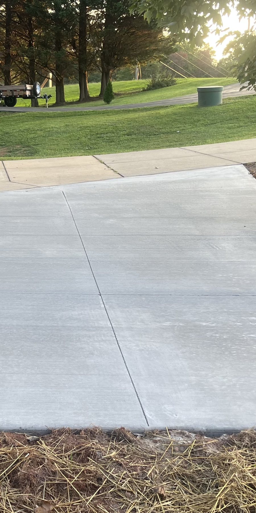 New concrete driveway apron poured to meet the existing sidewalk, broom finished with control joints