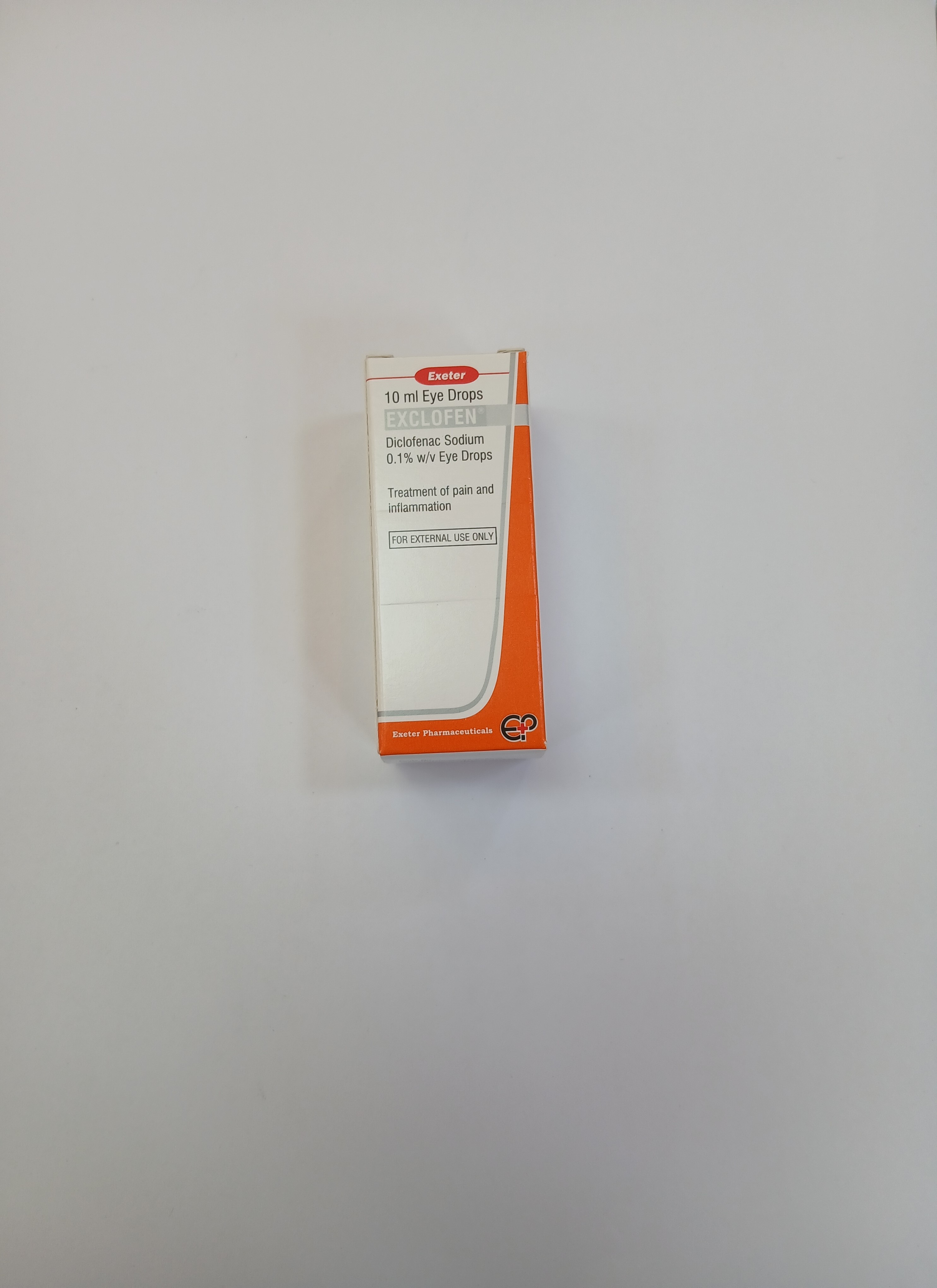 A small white rectangular box with an orange label and text printed in black, standing upright against a plain light background.