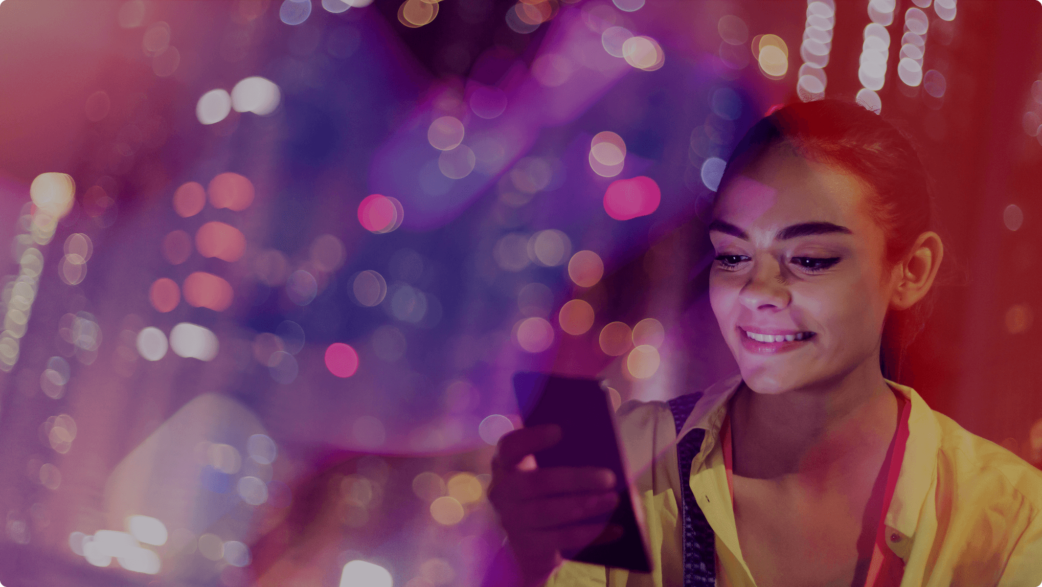 A woman looks at her phone, smilint