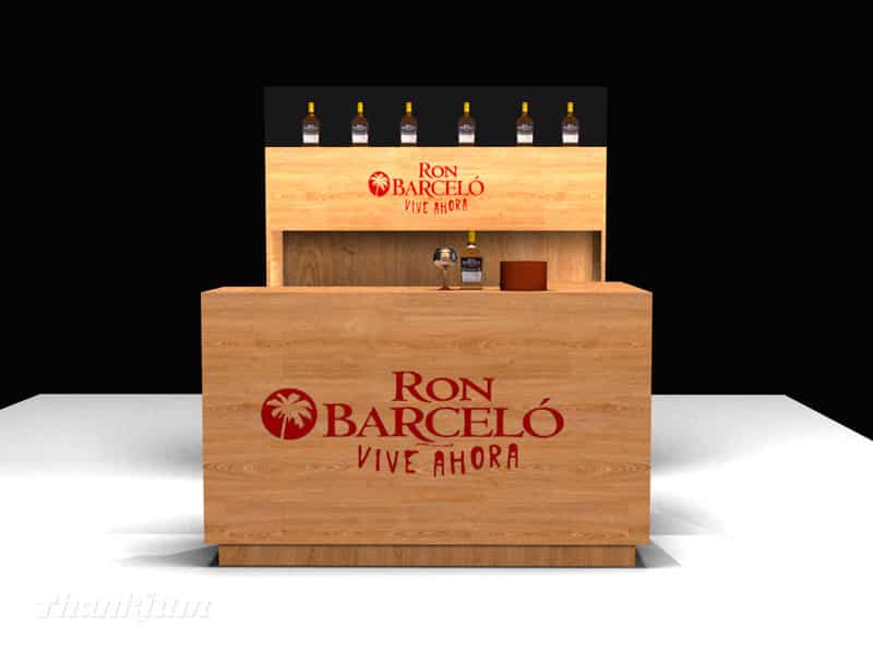 Mostrador de madera de Ron Barceló con botellas y logo, ambiente elegante.