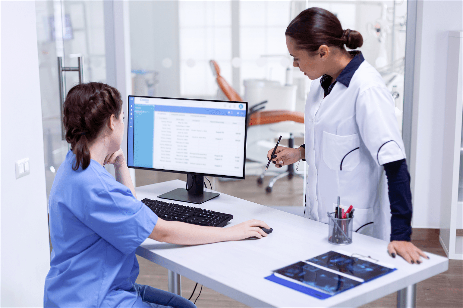 Healthcare staff reviewing digital medical records on a computer, showing how different types of medical records are managed and how IoT is changing them.