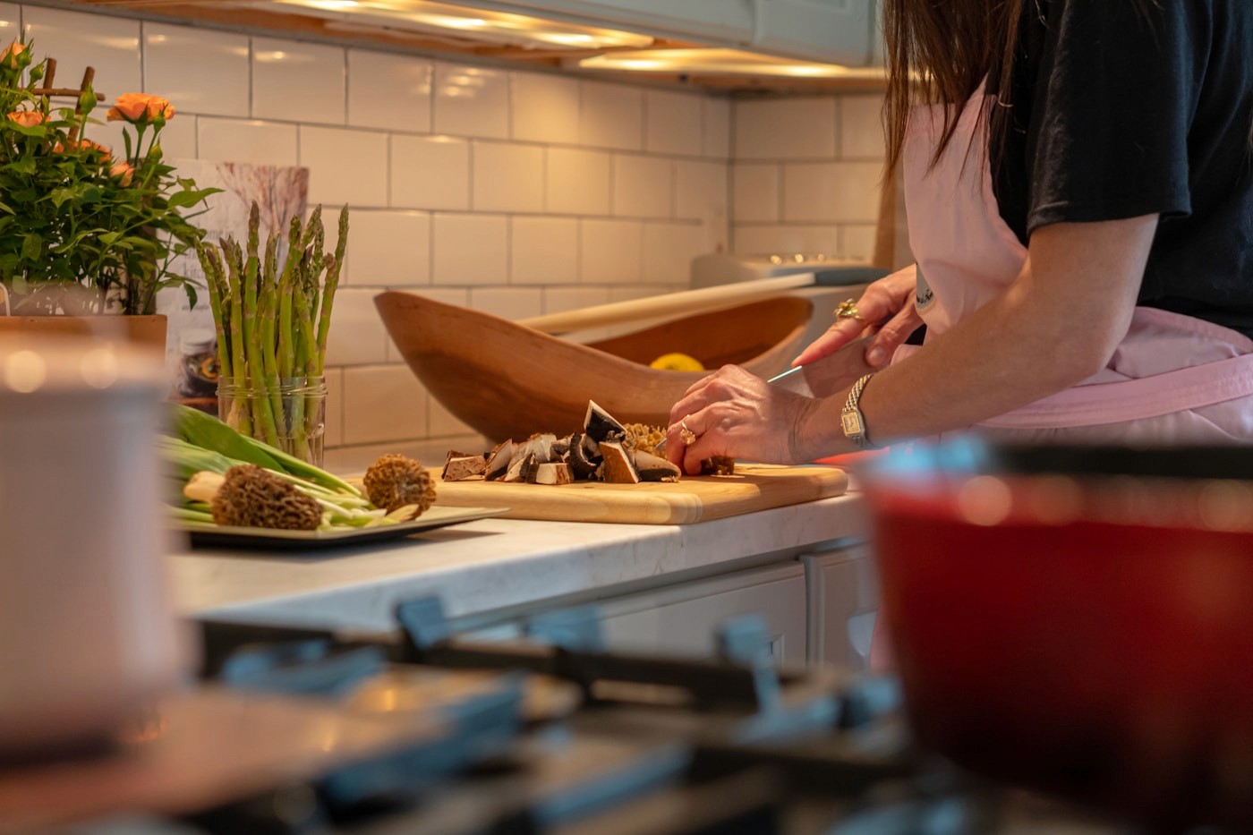 A woman preparing a fresh meal, chopping vegetables at a home kitchen counter