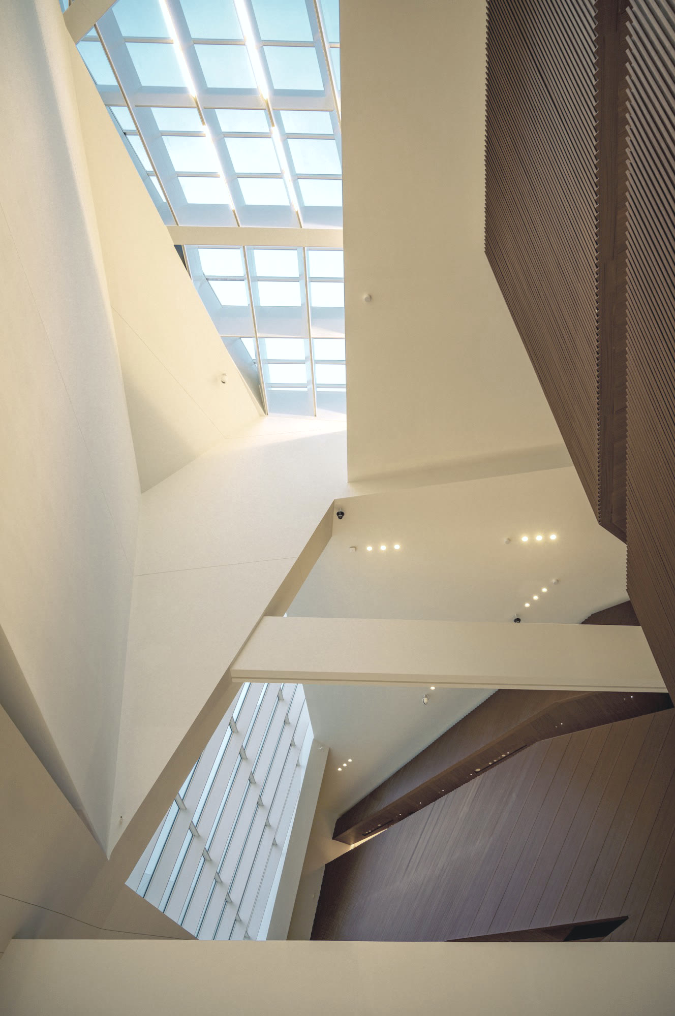 The atrium: white angular walls, oak panelling and a glass roof