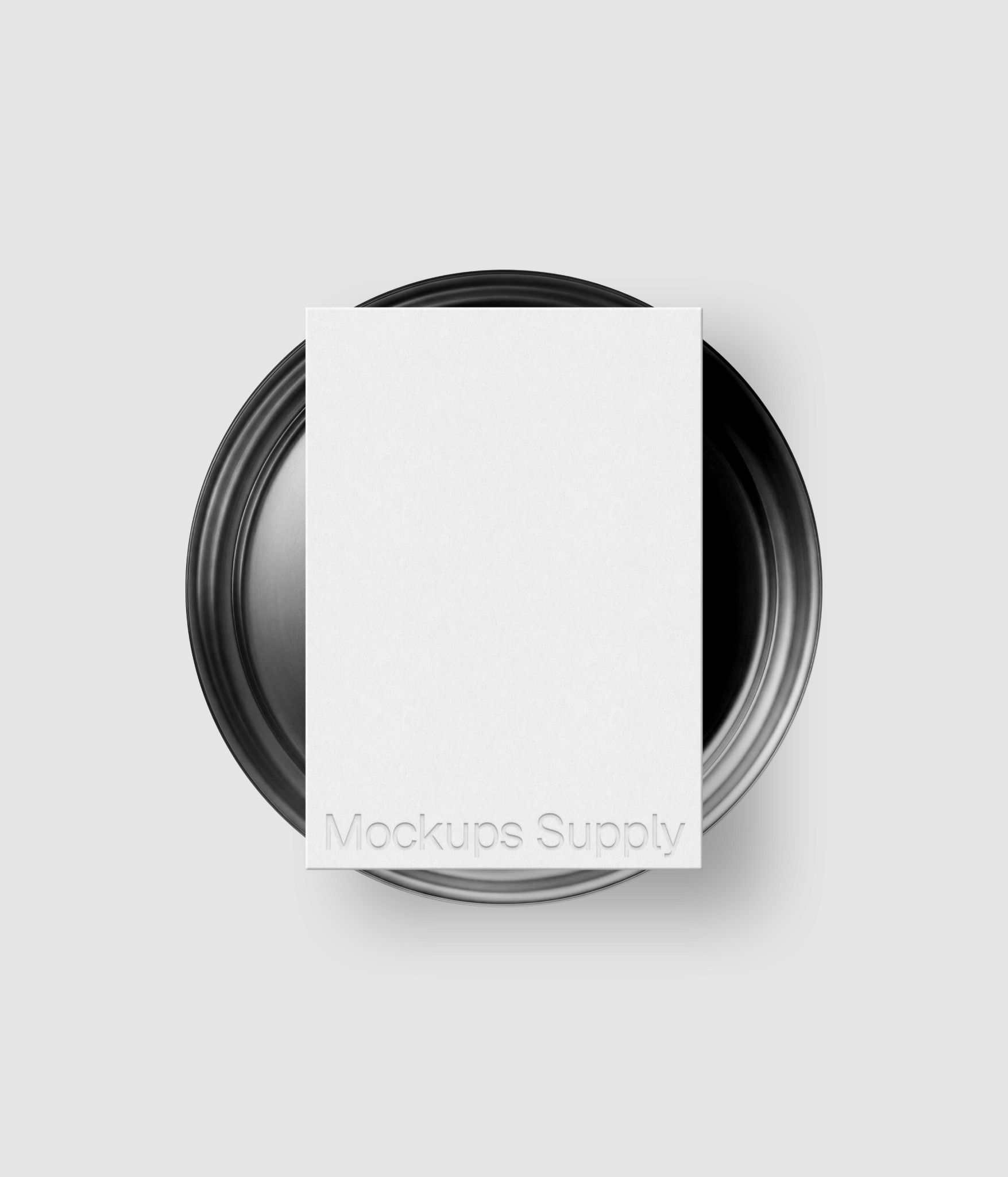 Paper card mockup with embossed typography on clean circular metal plate for logo design and identity showcase