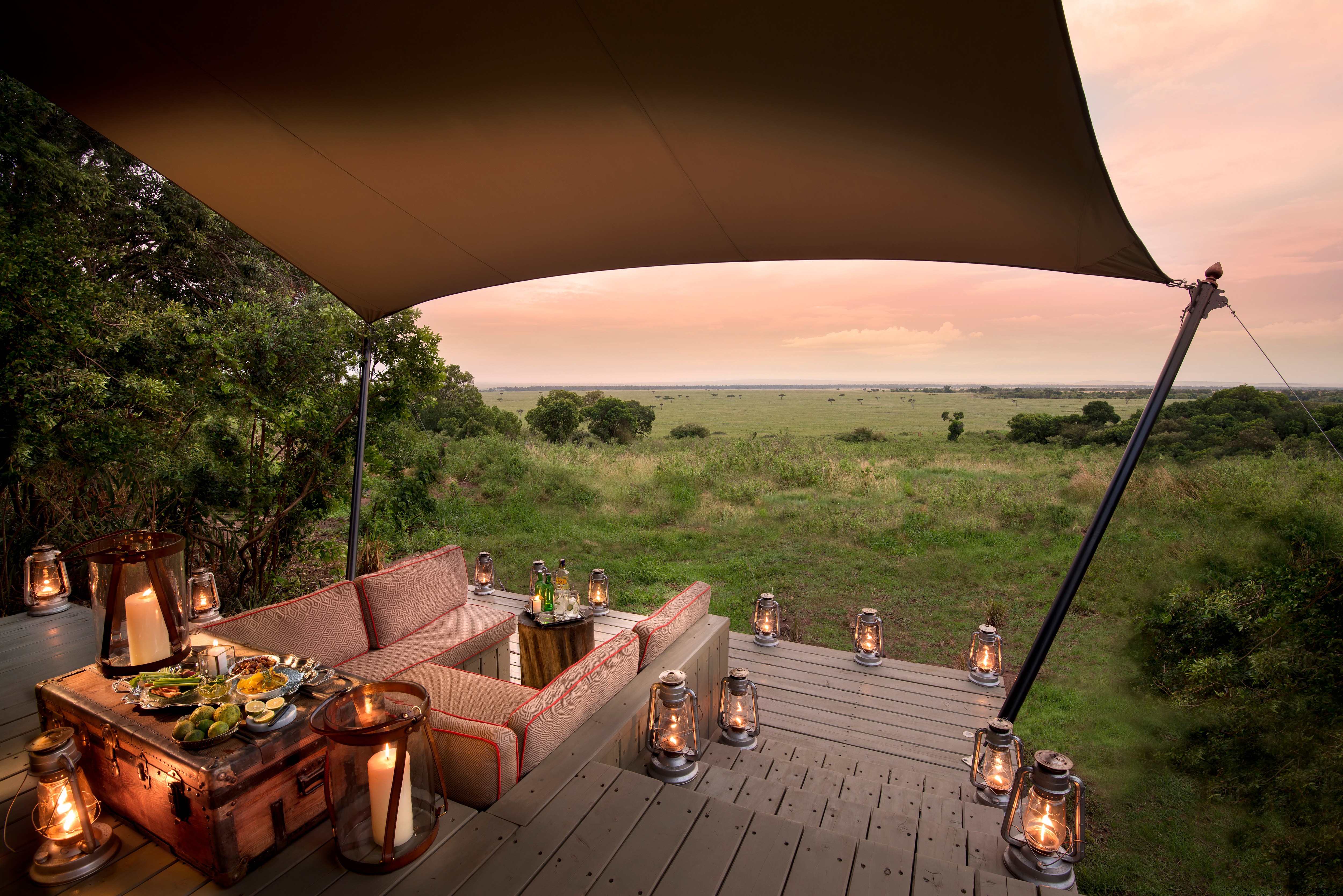 Sundowners on a tented suite's deck as dusk settles over the Mara