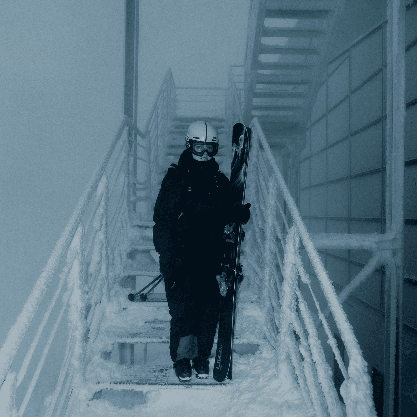photo of a female skier standing in icy and snowy stairs in ski resort.