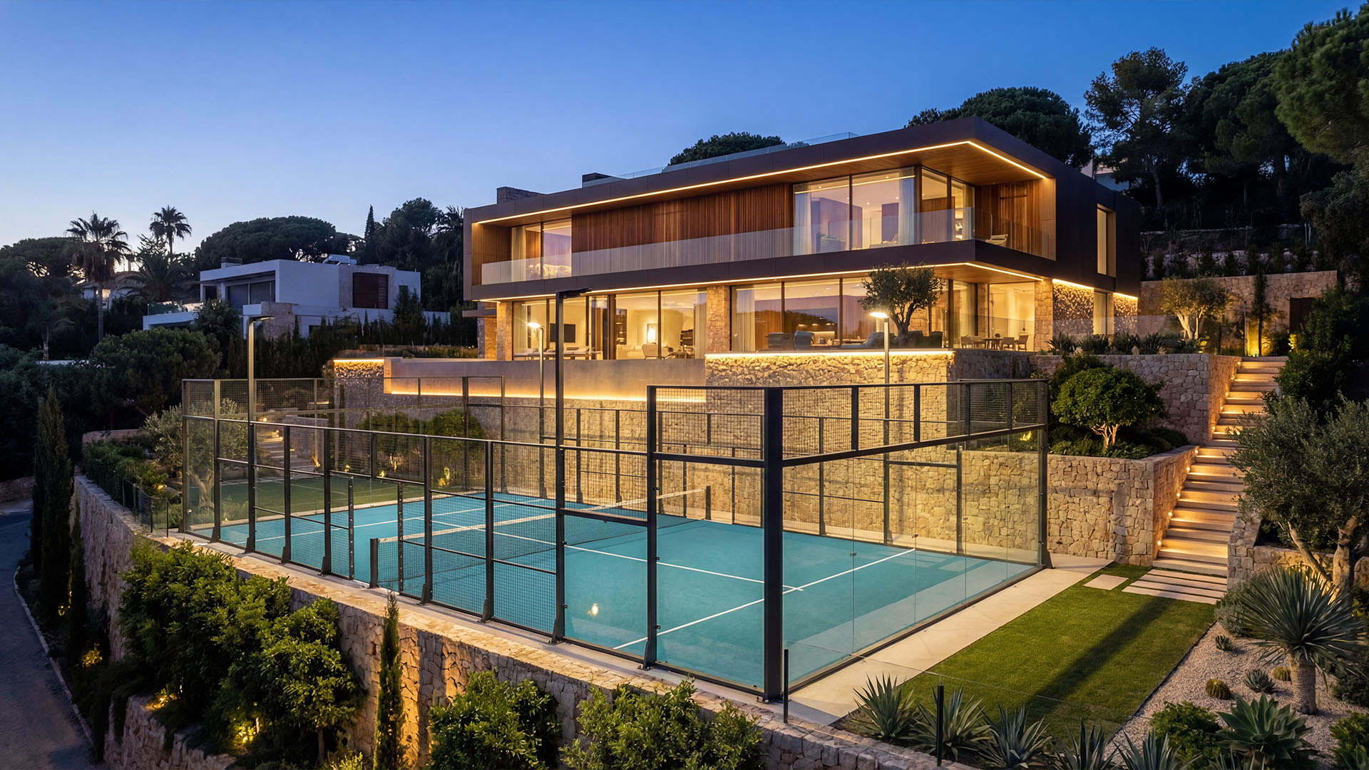 Contemporary Marbella villa with illuminated exterior and private padel court at dusk