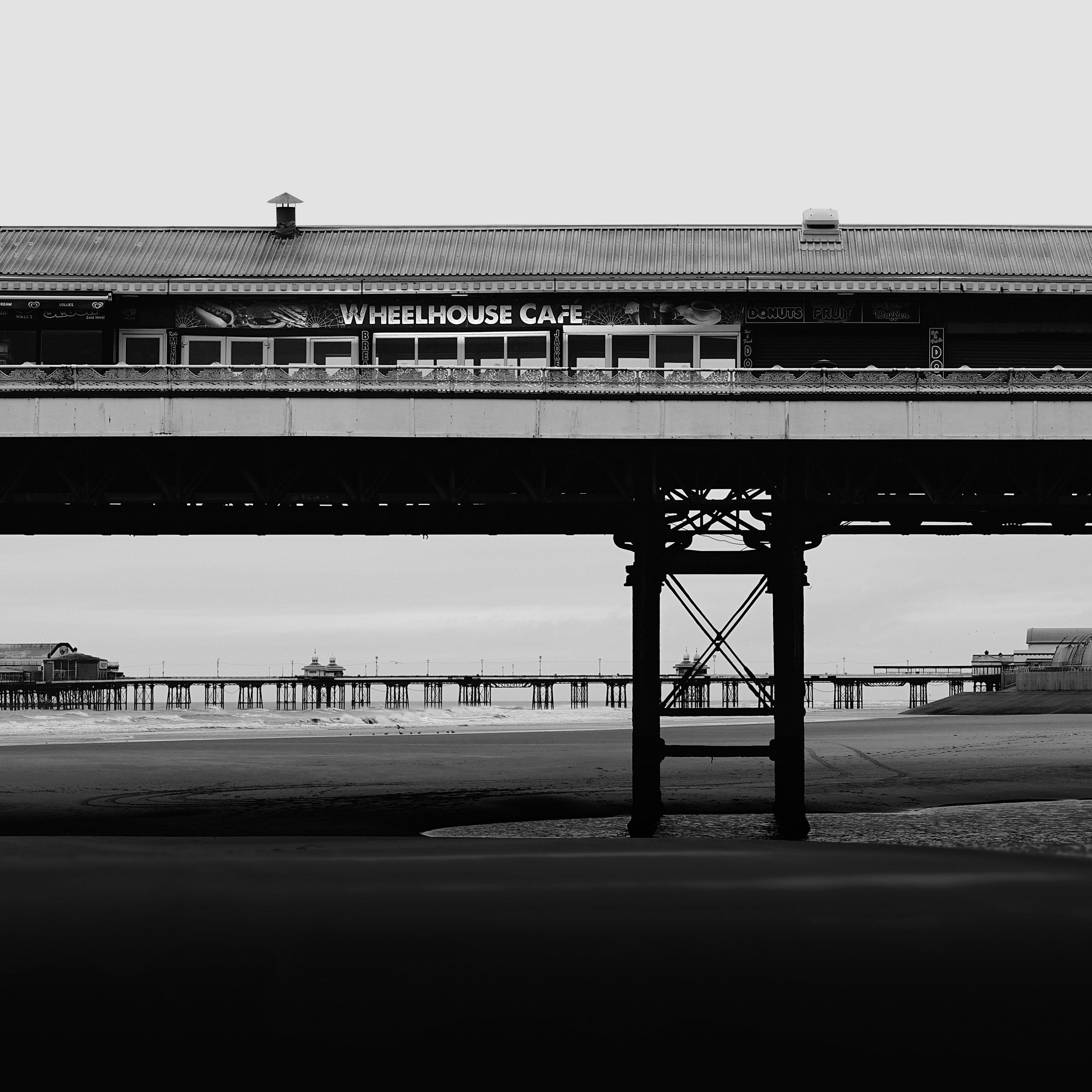 Black and white of a pier with a cafe