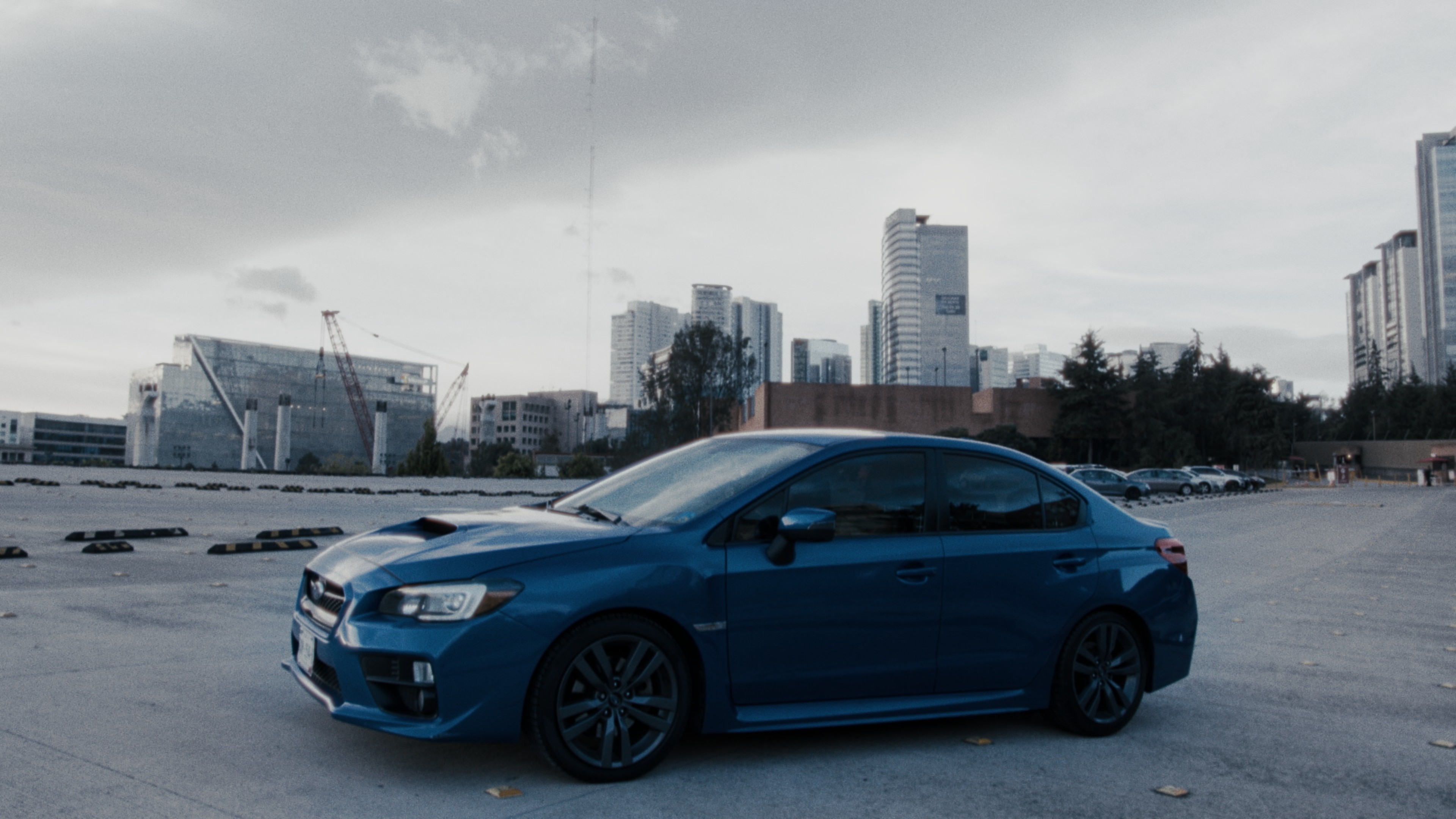 High-contrast automotive cinematography featuring a blue Subaru WRX against the modern skyline of the Santa Fe business district in Mexico City. A spec commercial directed and photographed by Mauricio Nader using a Blackmagic Pocket 6K G2.