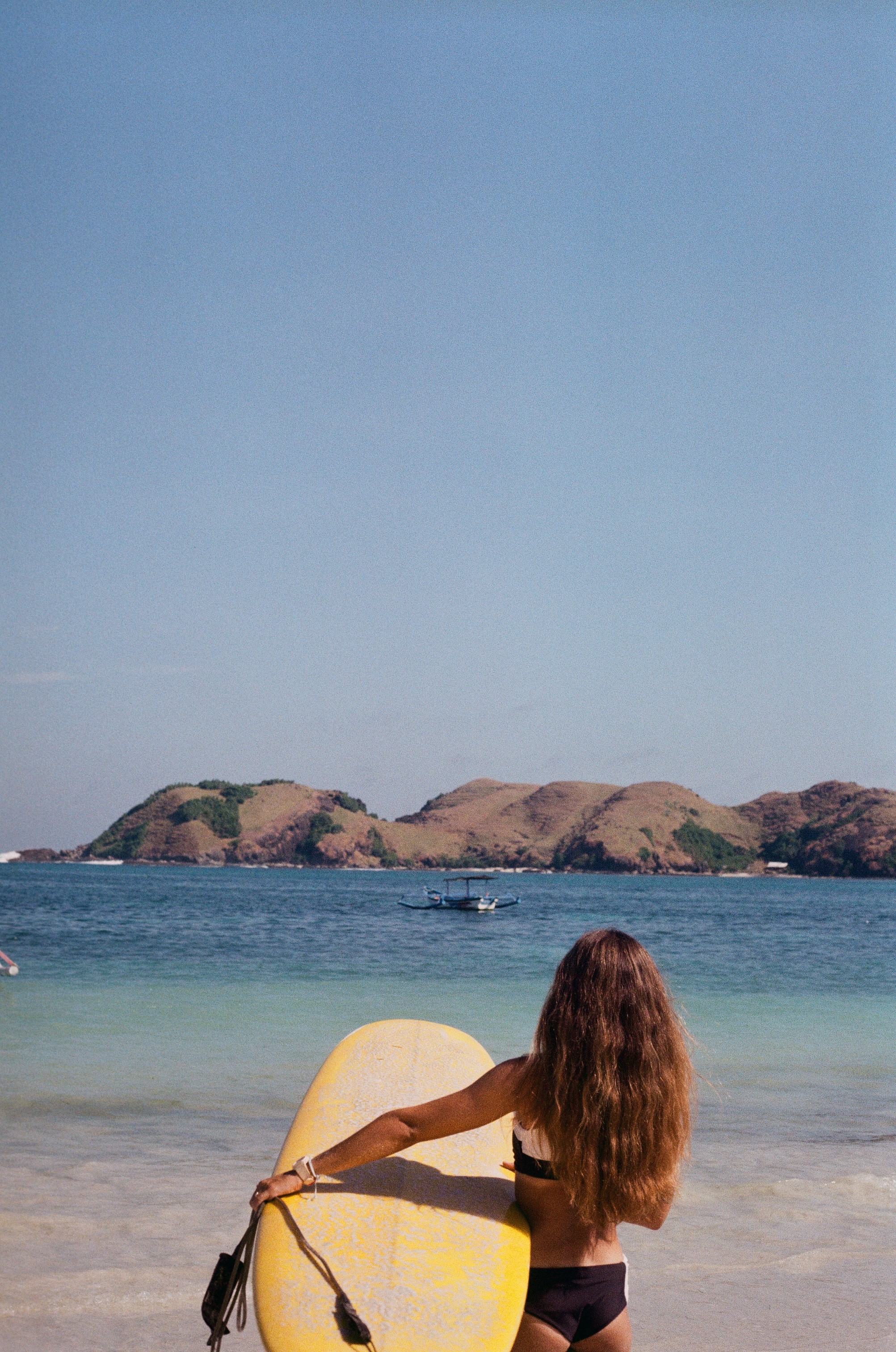 surfer girl with longboard in Lombok, Tnajuhan