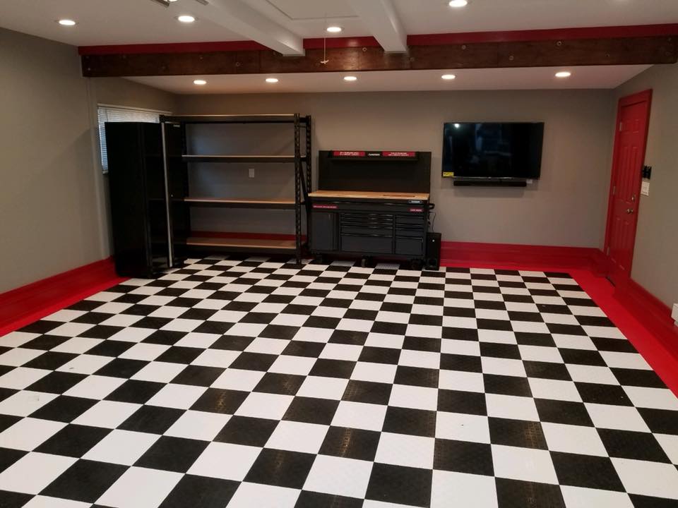 Garage renovation with checkered flooring, storage system, and workshop setup