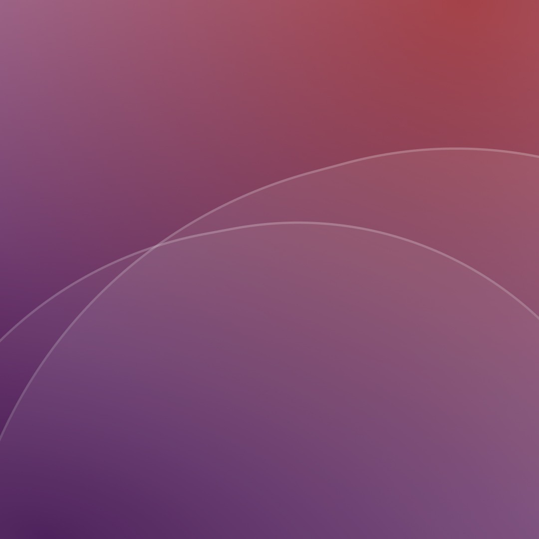 Mountain slope covered with trees next to a quiet lake, with mist and layered peaks in the distance.