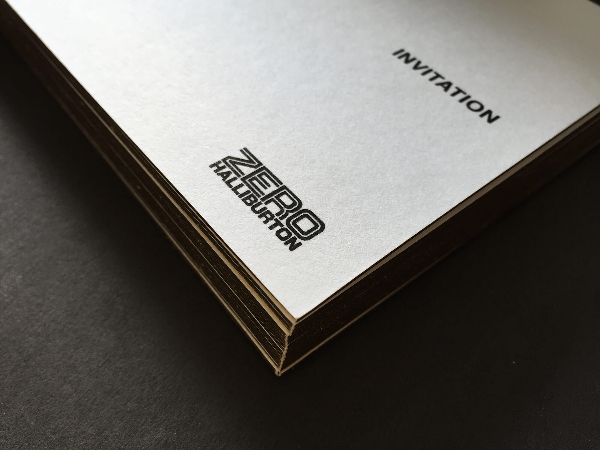 這張圖像展示了ZERO Halliburton的活動邀請卡，卡片使用厚紙卡且邊緣採燙金效果，上面印有品牌標誌。