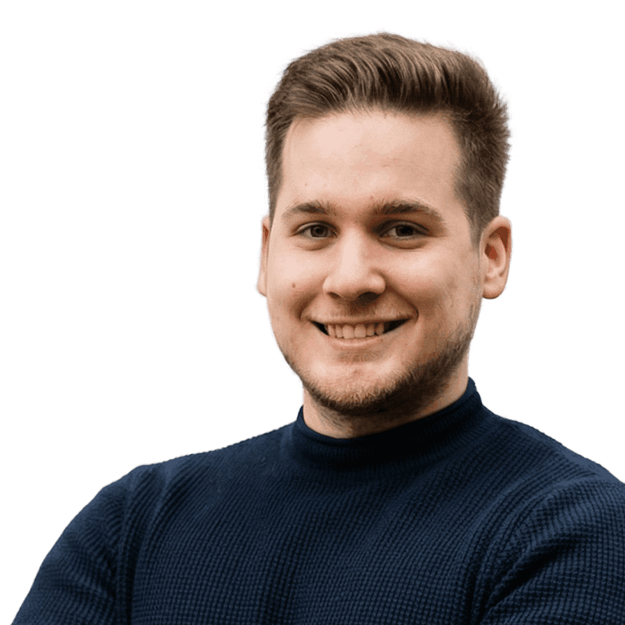 Smiling man with short brown hair wearing a blue turtleneck