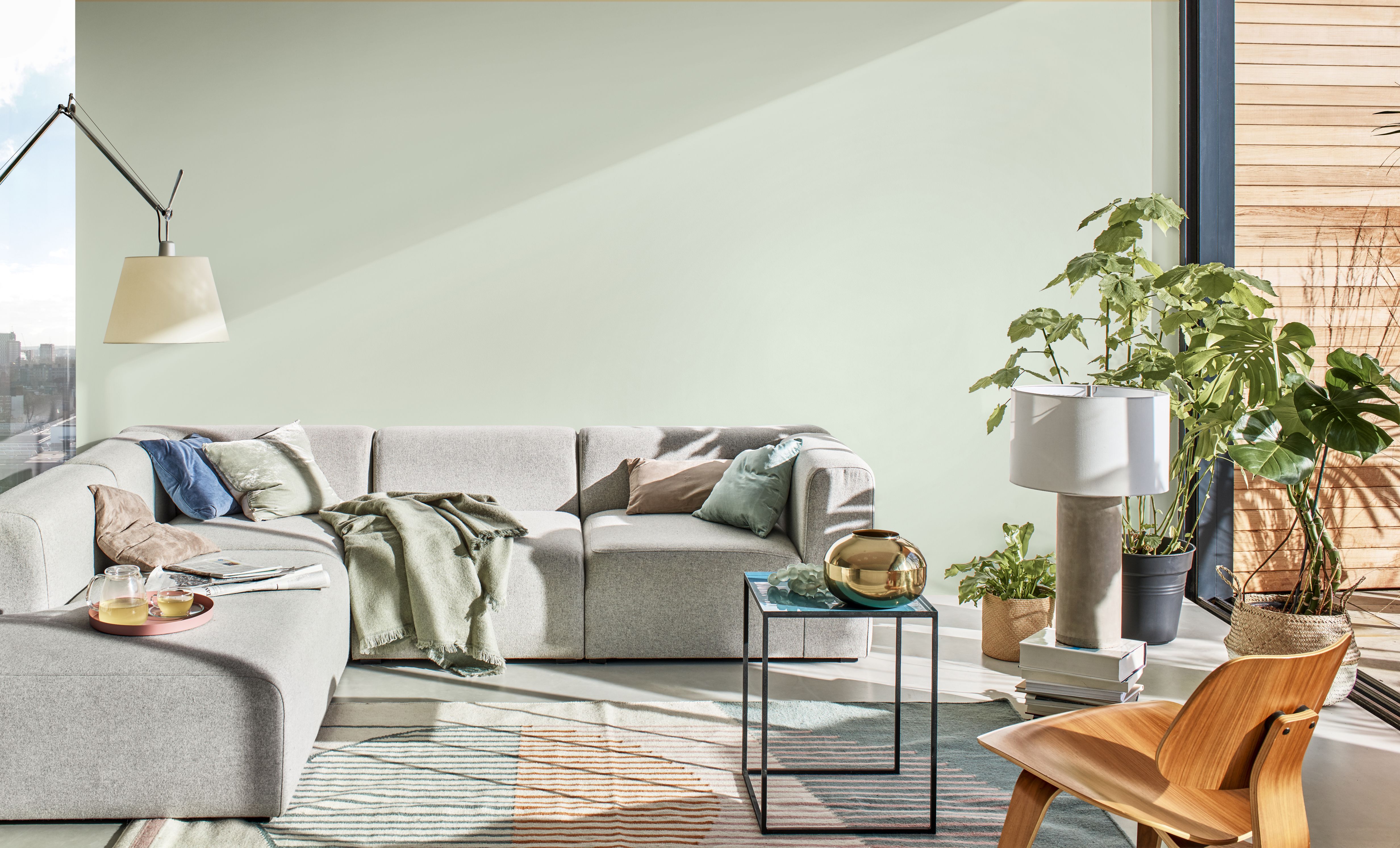 licht groene muur met grijze bank 