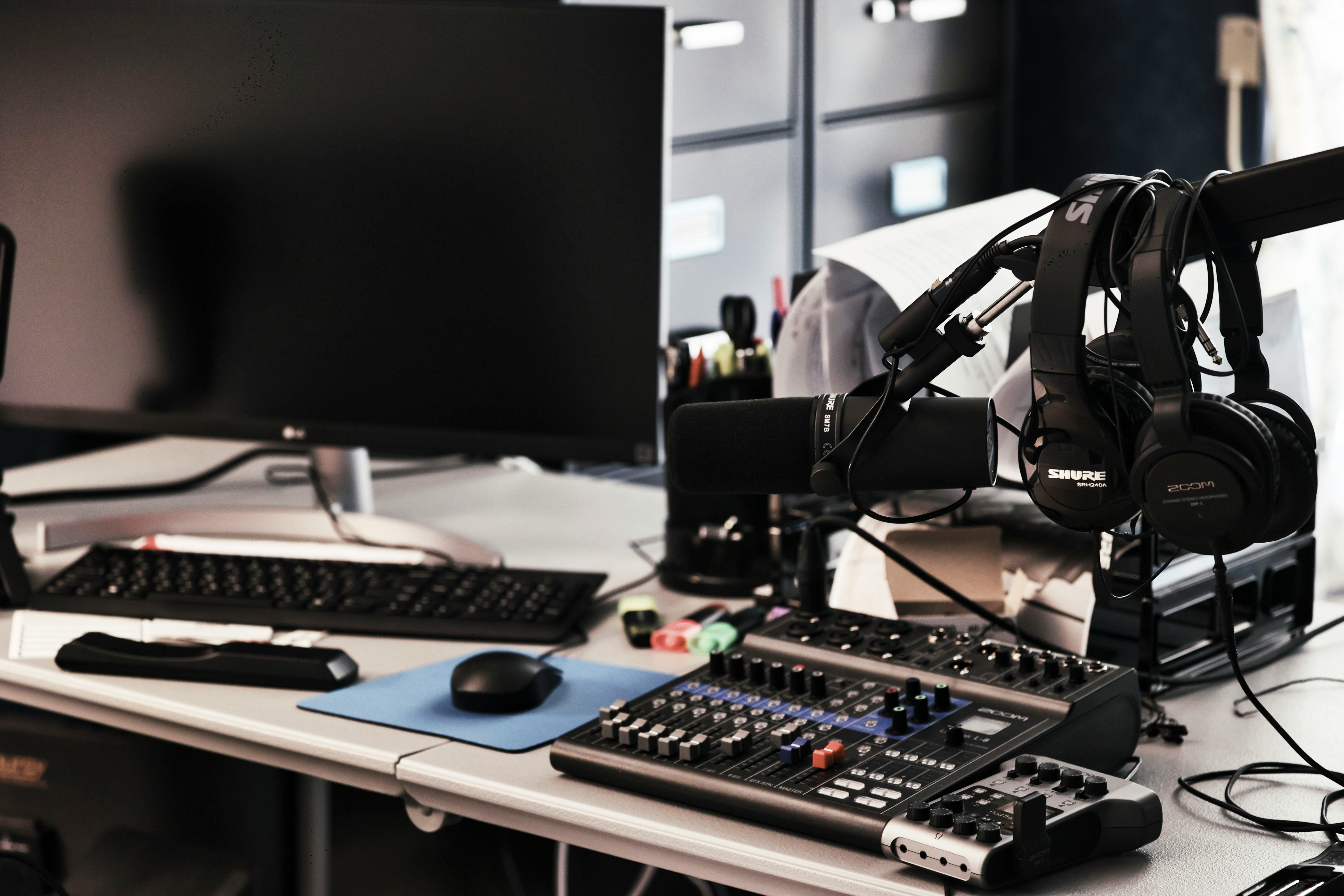 a computer desk with a microphone and headphones on it