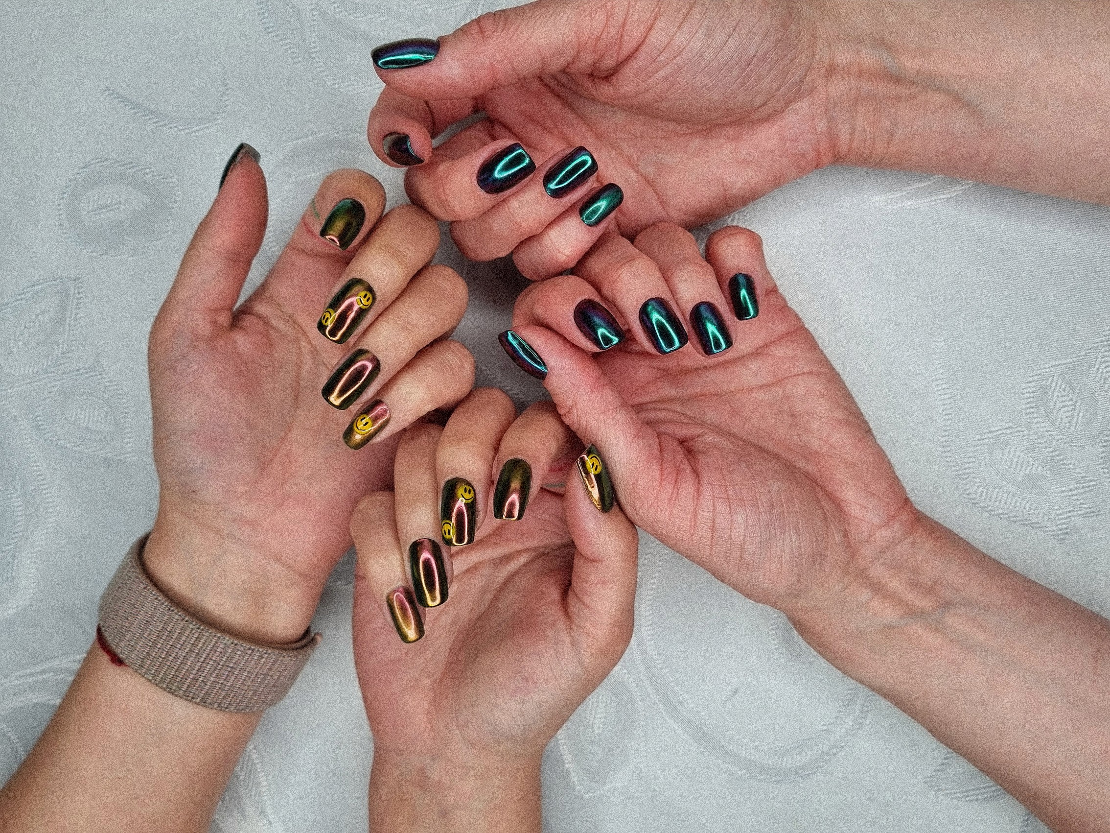 Hand with light pink nails and rings on cozy blanket