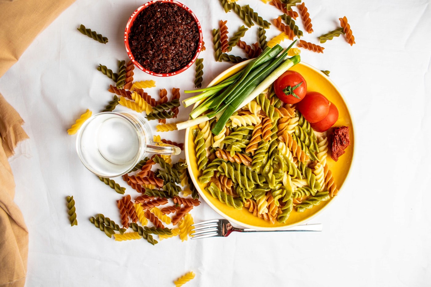 A colorful plate of pasta with green beans and tomatoes, a carbohydrate-rich meal that fuels a runner's glycogen stores