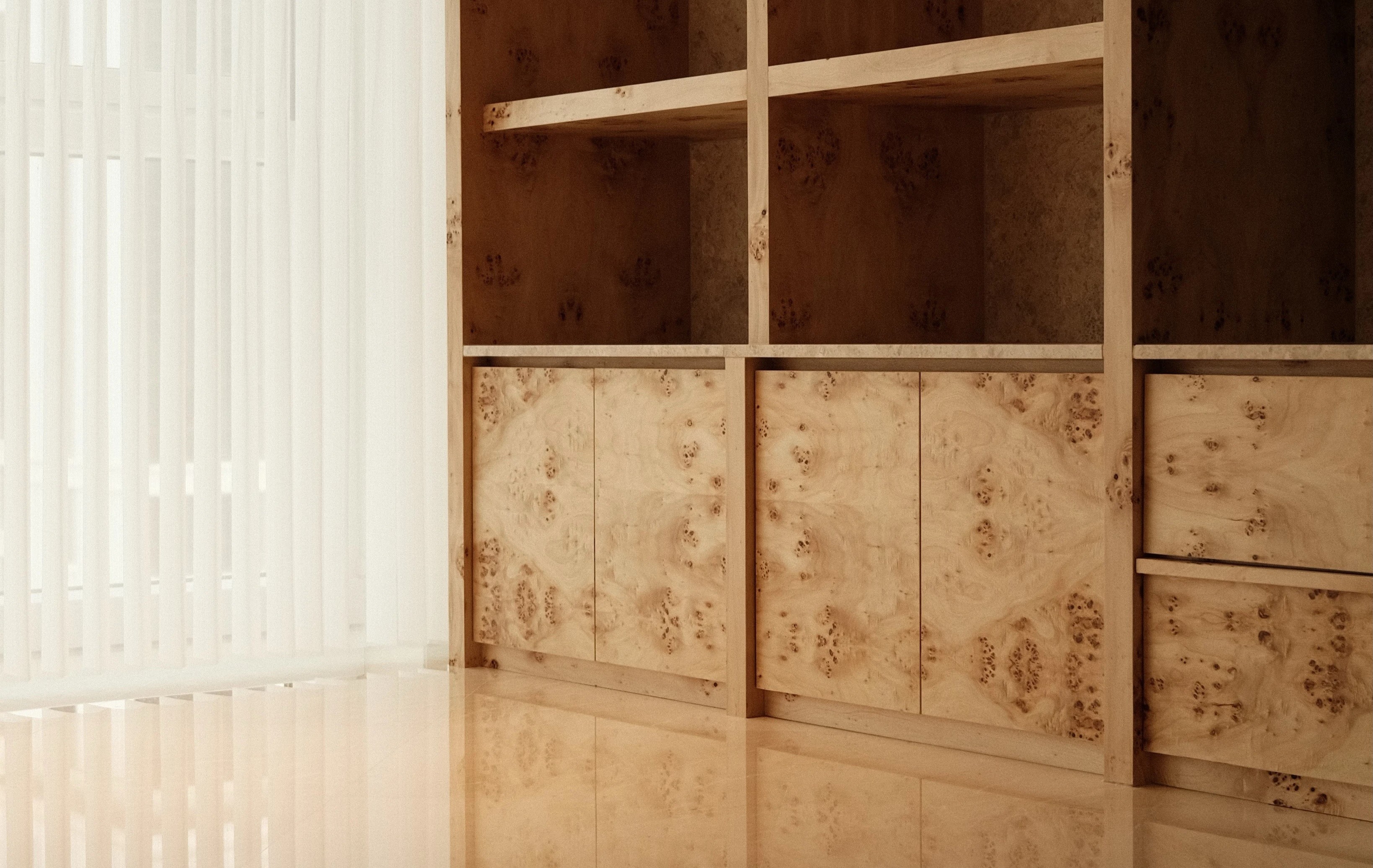 Built-in wooden shelving with natural finish, minimalist storage solution by Persqft interior design