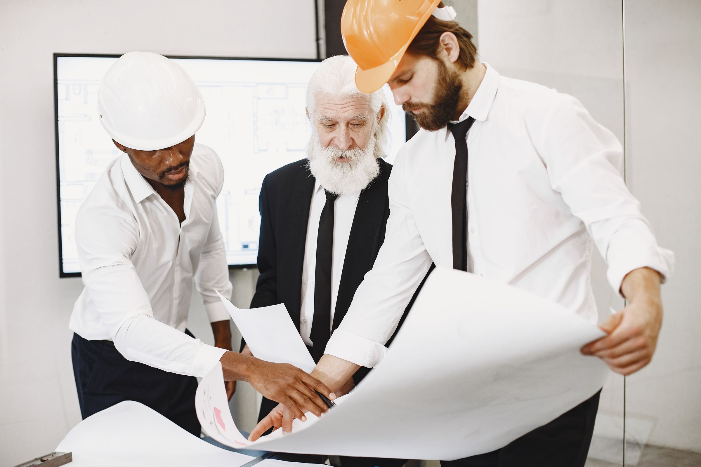 Three architects reviewing drawings together in an office