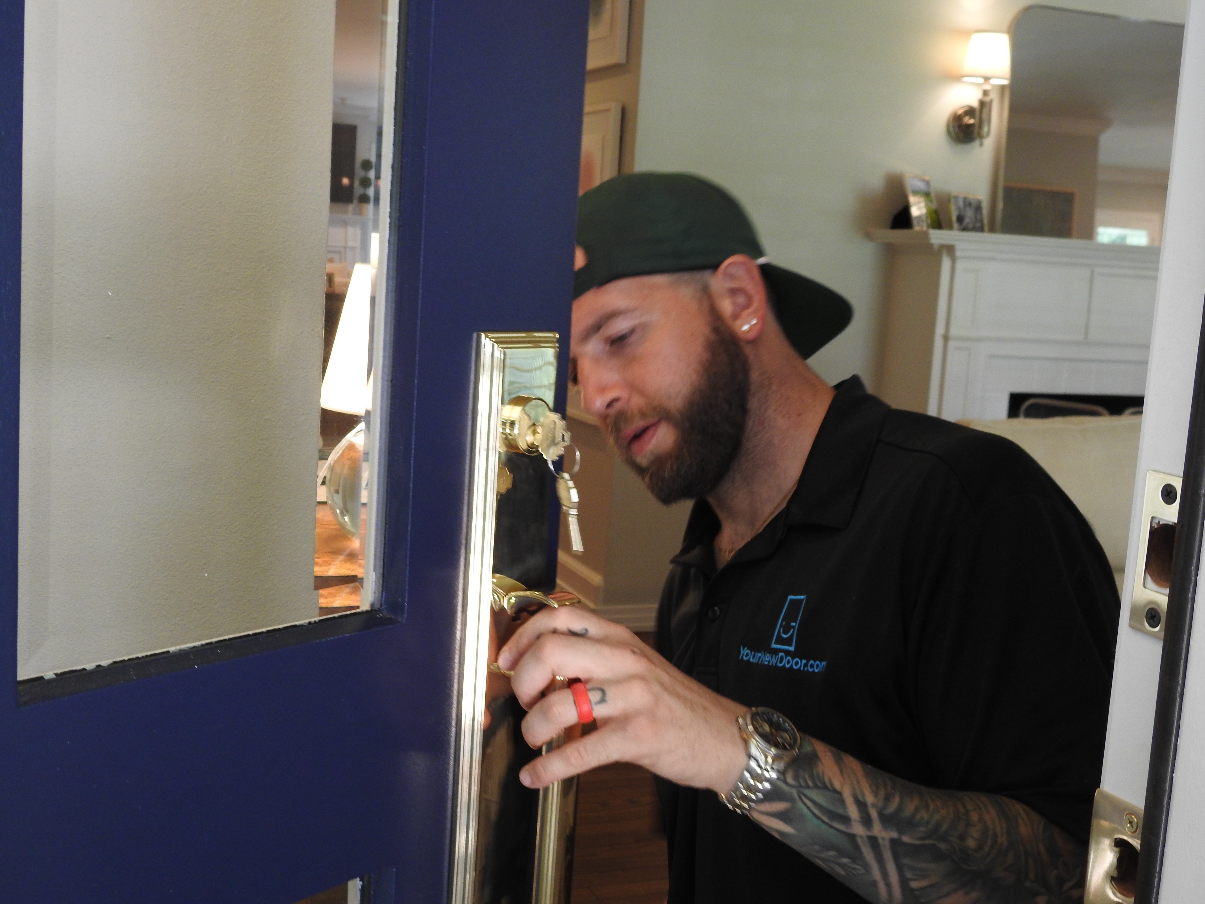 A your New Door technician working on the lock hardware of a door on a home in the Highland Park neighborhood of Dallas, TX.