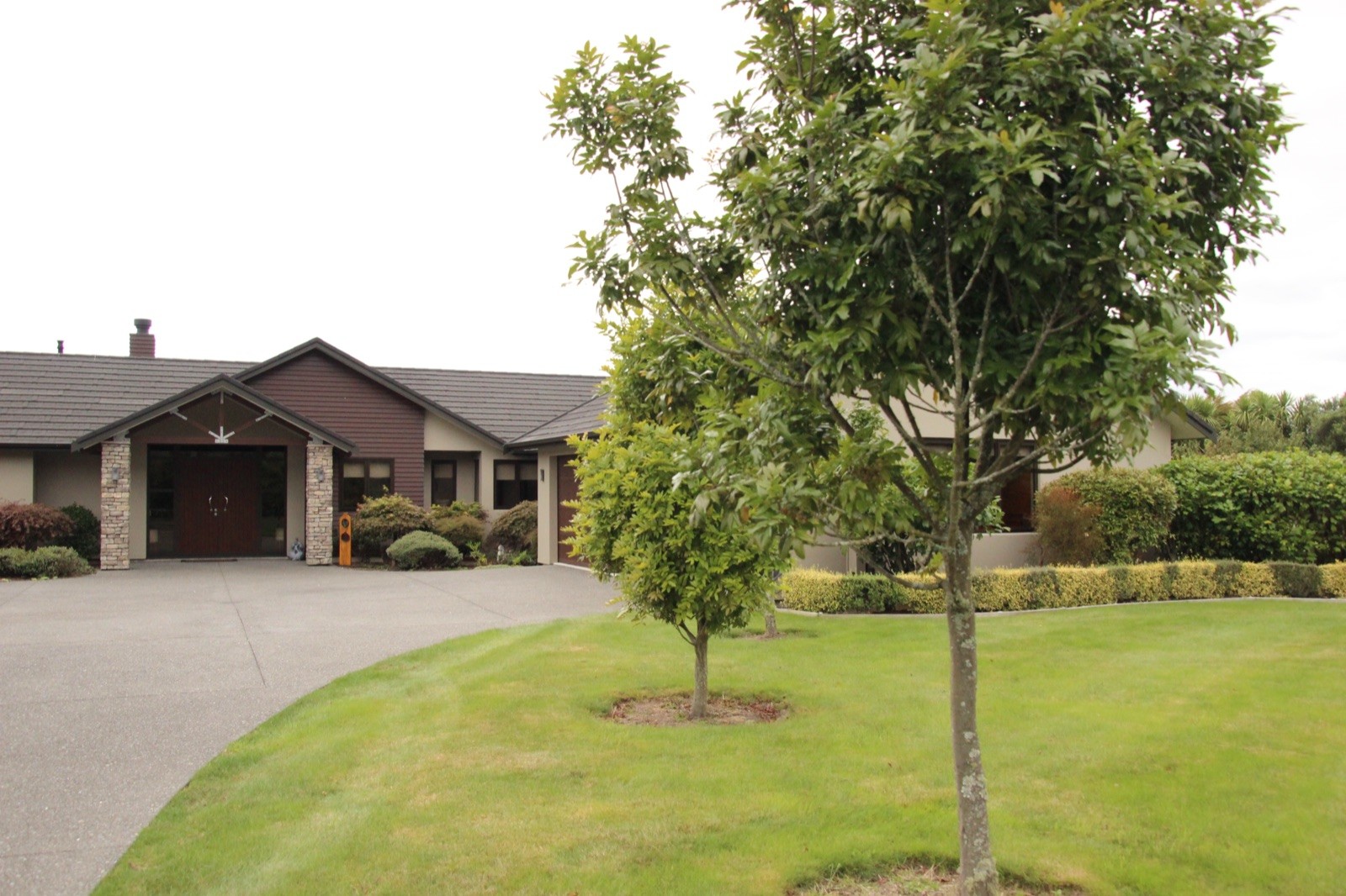 Landscaped lawn and curved driveway at the Parklands home in Rotorua