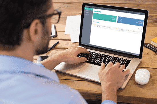 A smiling woman doctor is sitting at her desk and looking at a computer screen showing a medical screening test.