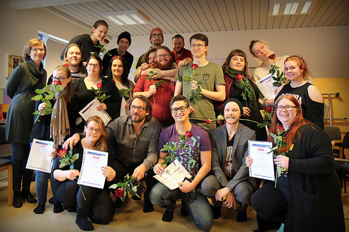 Smiling man wearing glasses and a pink shirt, showing his arm with a bandage after vaccination.