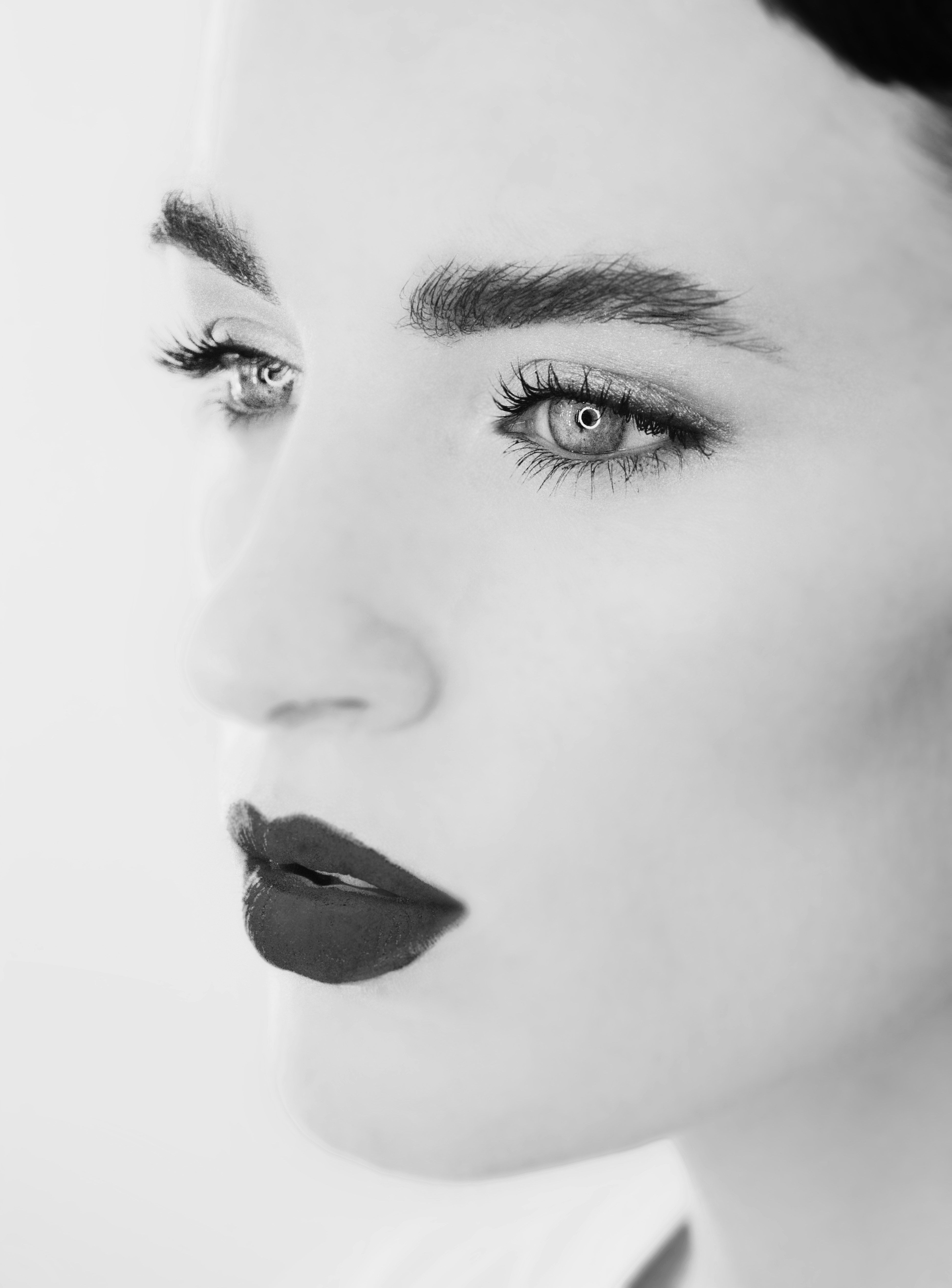 High-contrast editorial portrait of a woman representing the Aura Collective's global aesthetic standard in refined transformation.