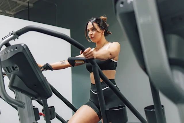 Woman exercising on a cardio machine, concentrating on her movement
