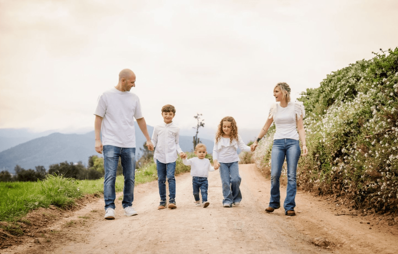 Familia cogida de la mano en un paseo rodeado de naturaleza