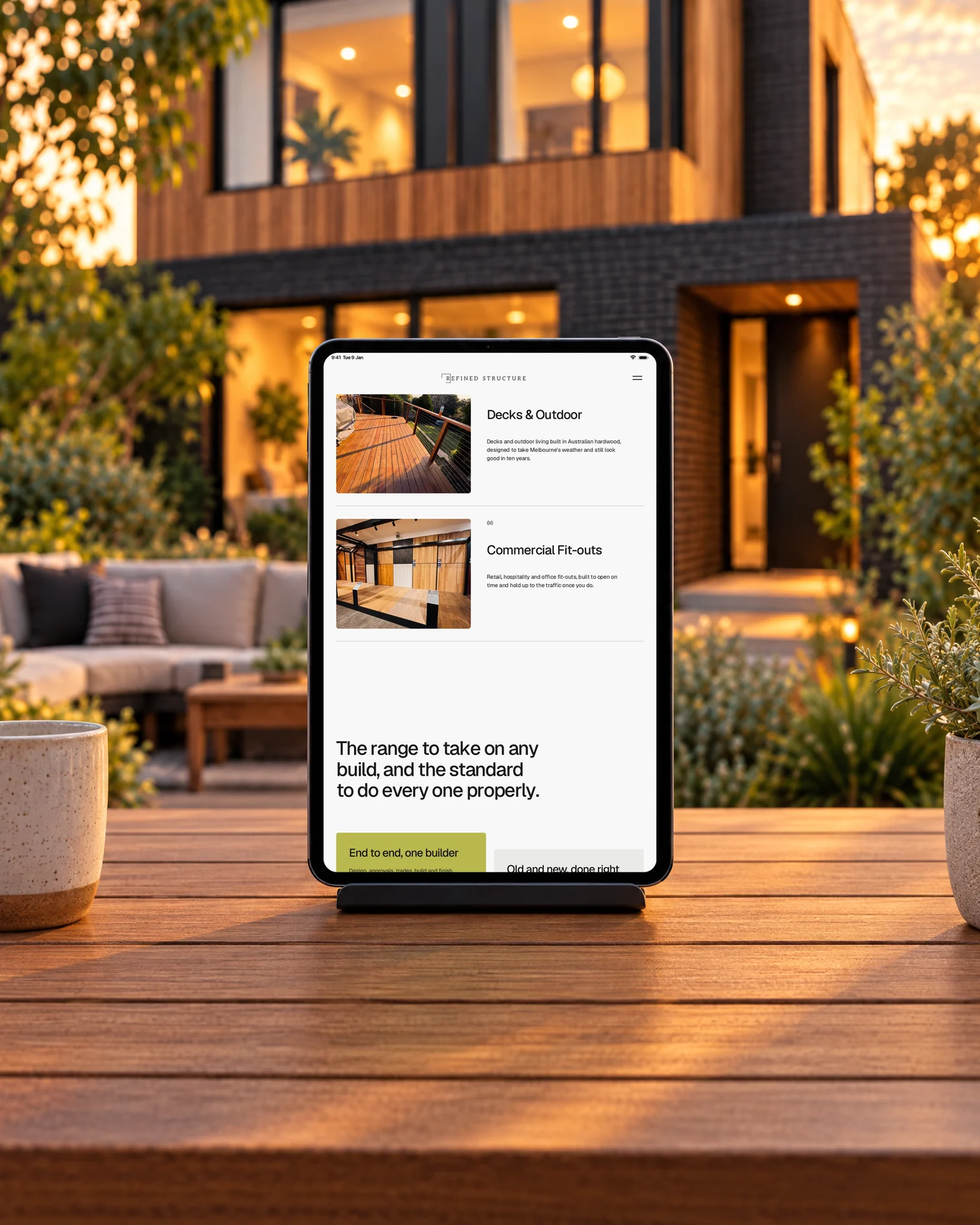 An iPad on a stand on a hardwood deck at dusk, showing Refined Structure's Decks and Outdoor service.