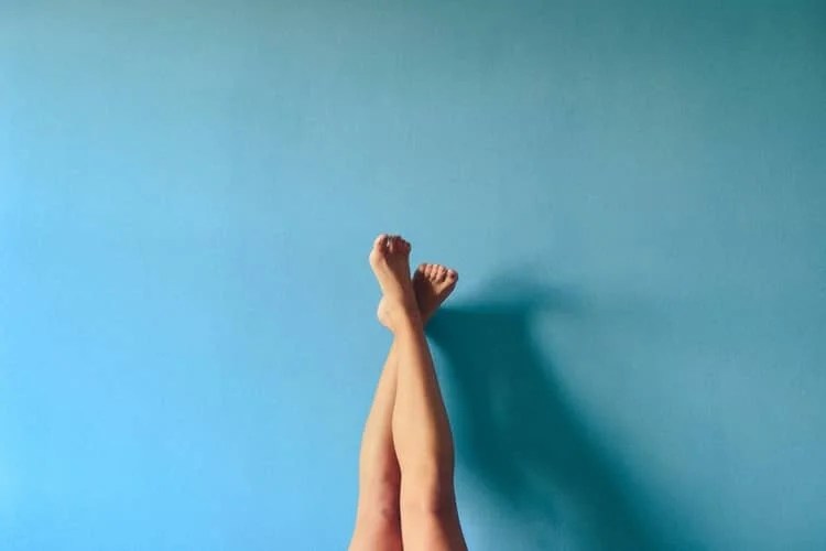 a pair of legs crossed and rested against a wall