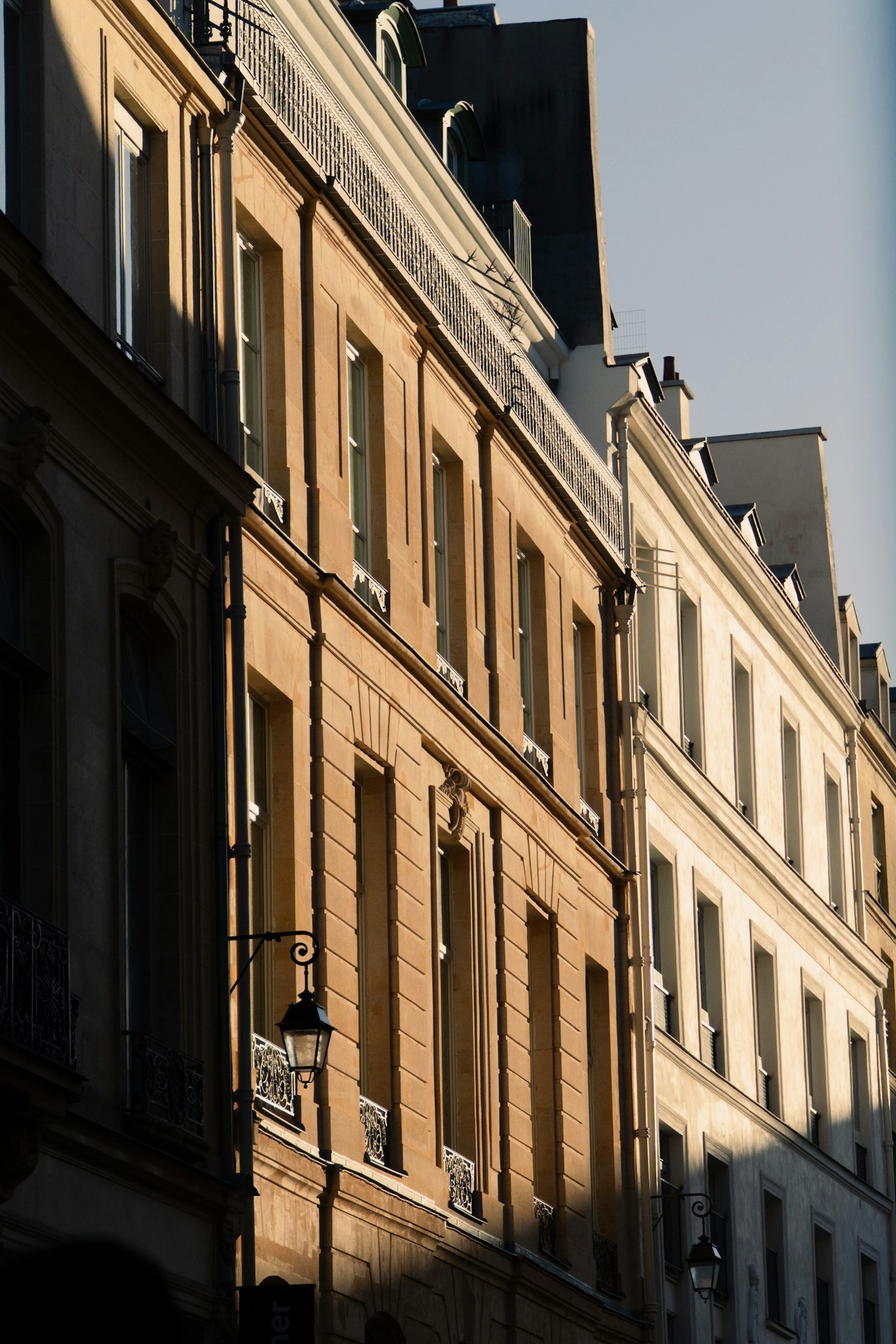 Façade haussmannienne en perspective, pierre de taille beige au soleil
