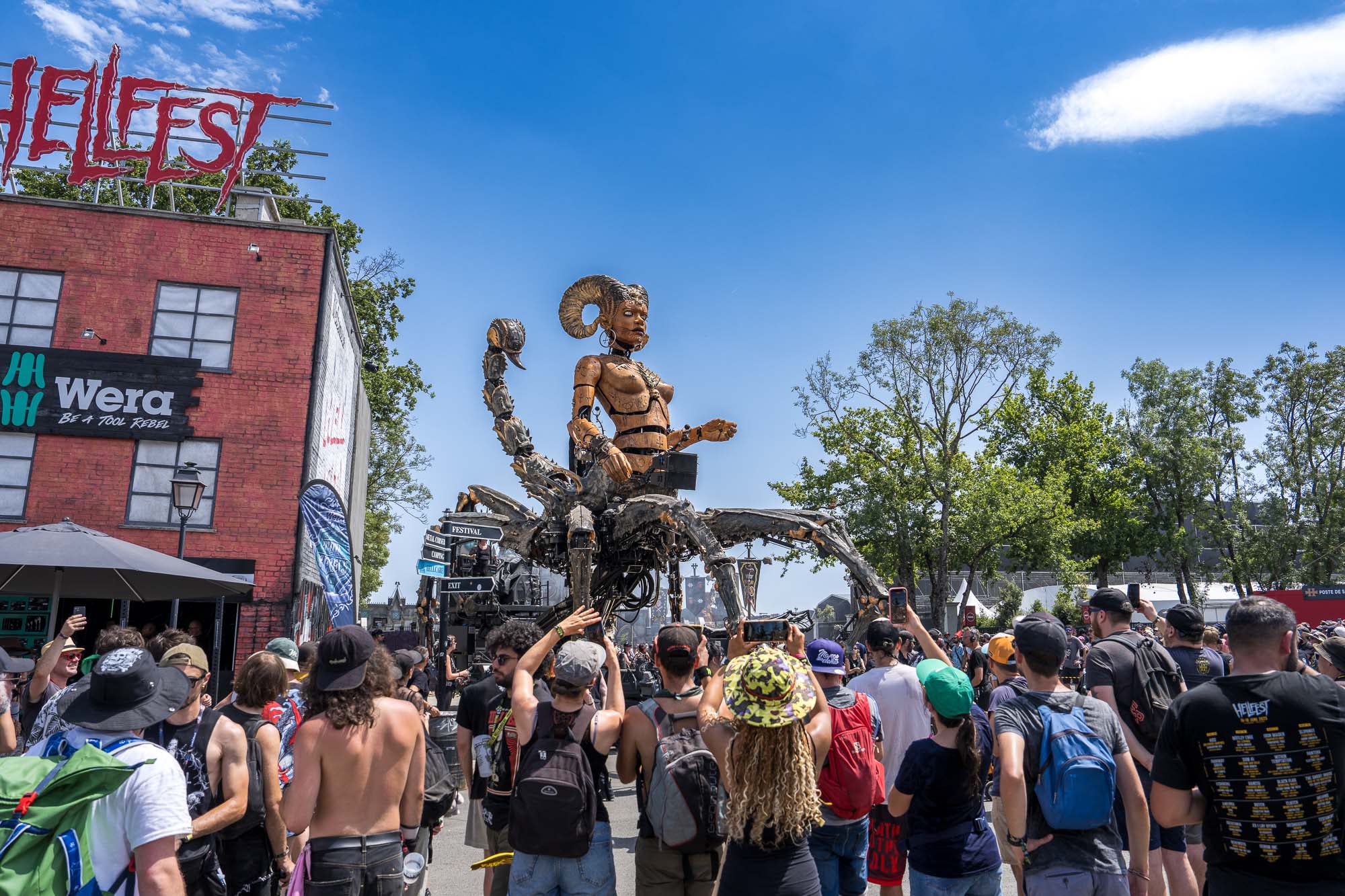 La sculpture-scorpion géante entourée de festivaliers sous l'enseigne Hellfest, Clisson 2026