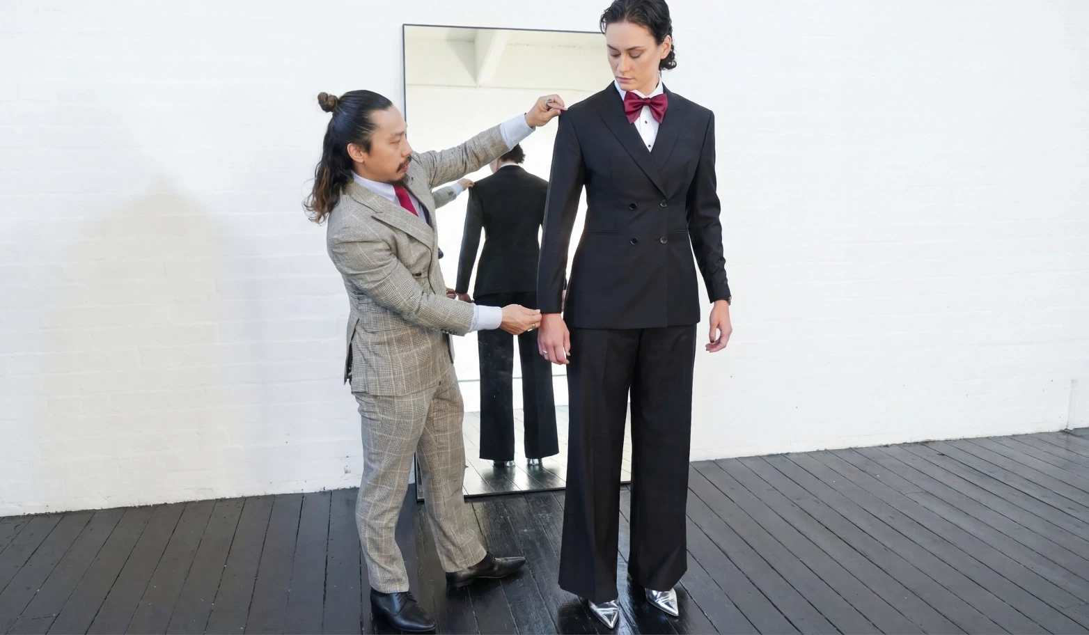 Peter fitting a suit on Jesse during a tailoring session