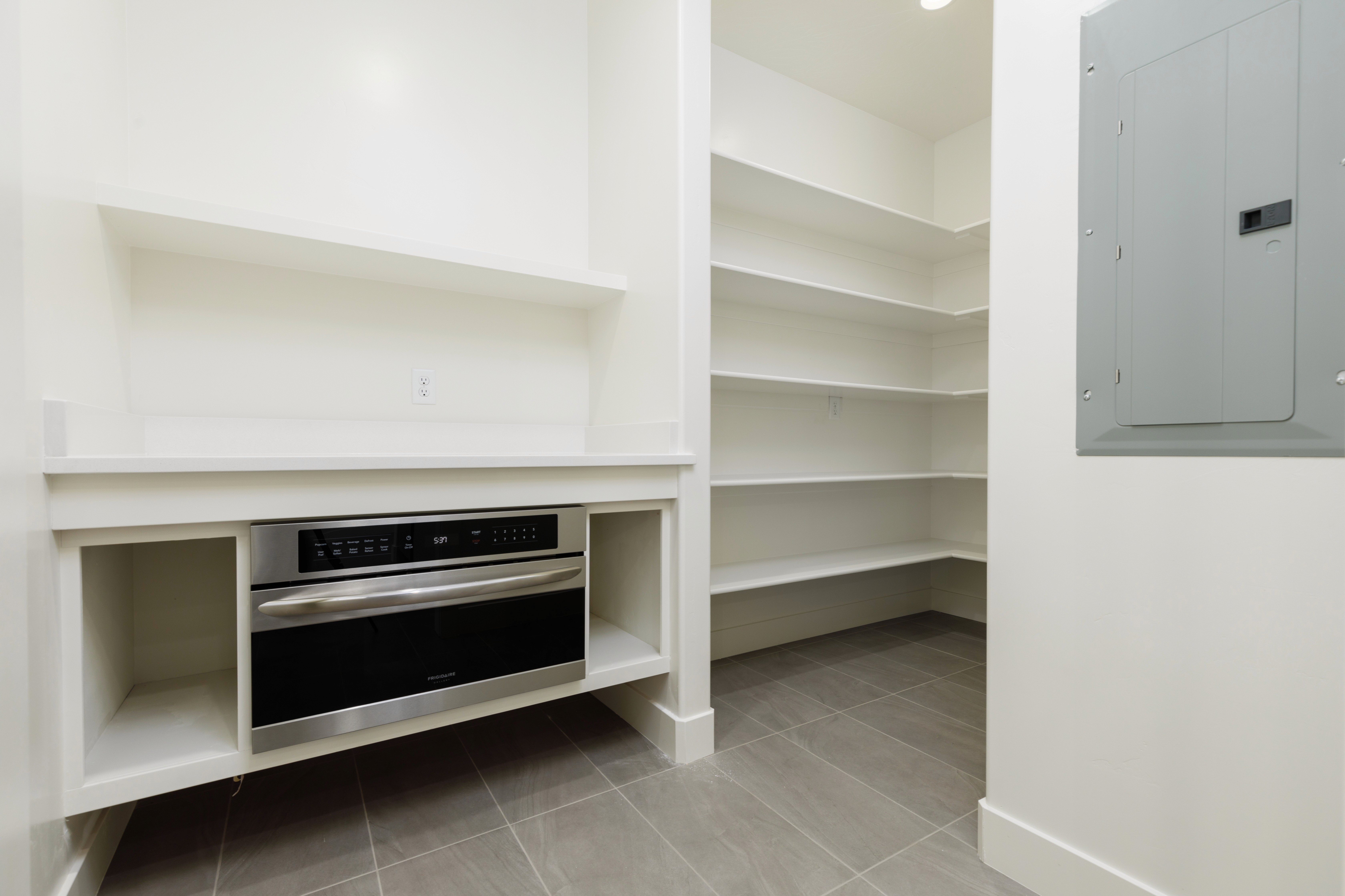 Walk-in pantry at Mountain View’s Cove featuring shelving storage and a built-in wall oven in a Washington County home.