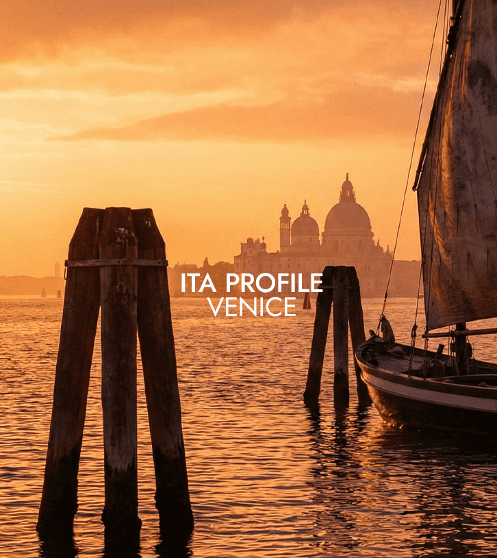 Venice lagoon at sunset with wooden poles and boat, calm water