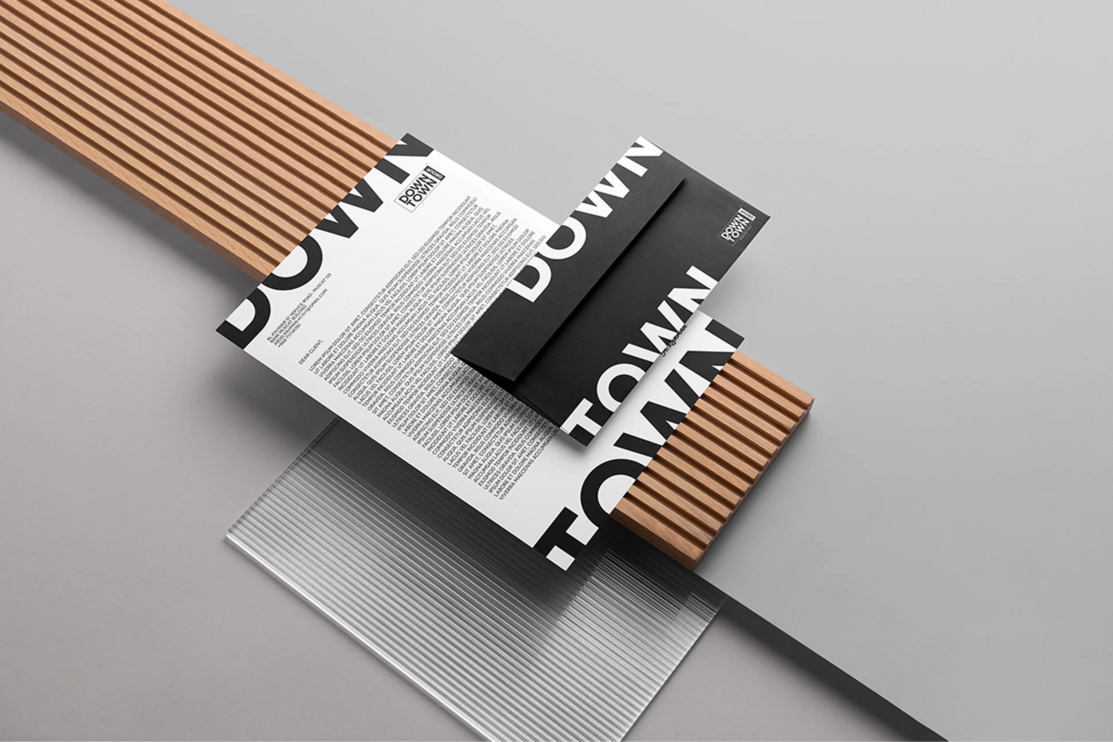 Downtown Group branded collateral card in black with logo and geometric mark on textured wood surface