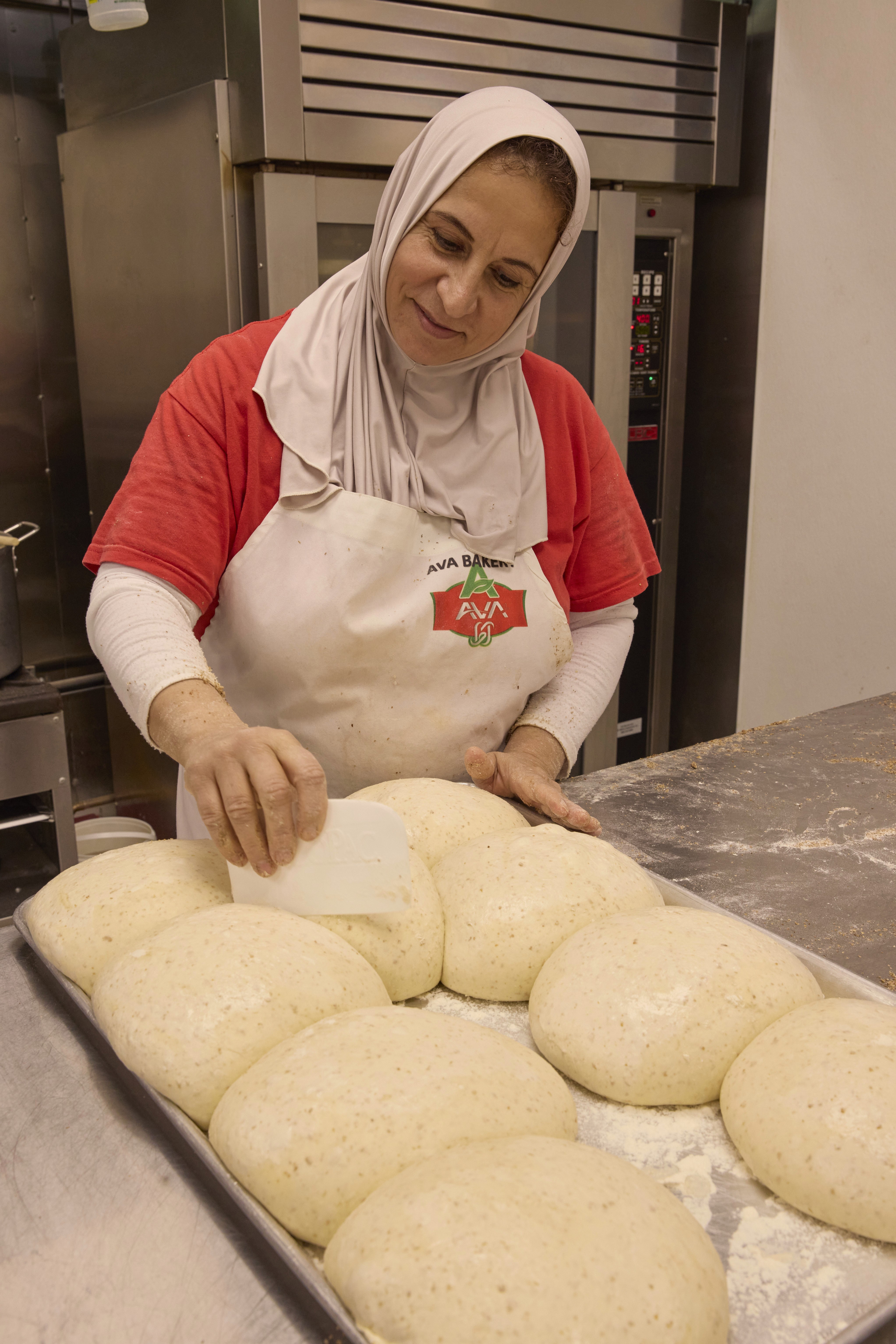 A men's volleyball team wearing blue jerseys gathered in a tight huddle on the court.