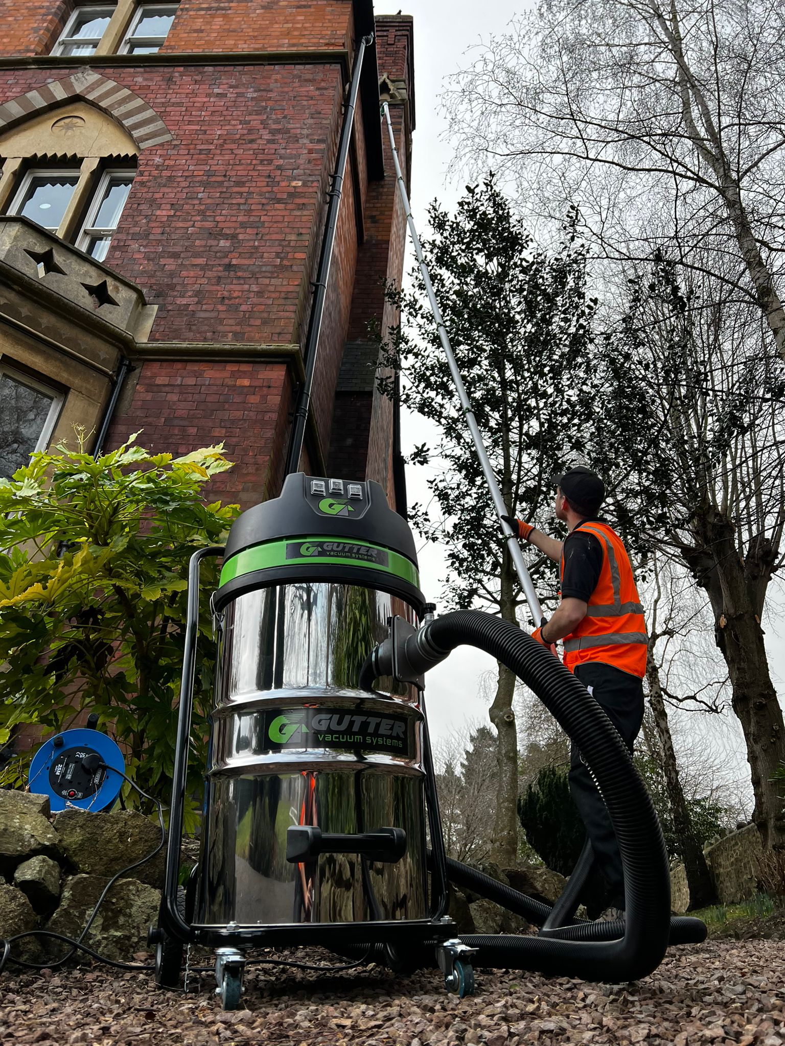 Gutter vacuum system removing leaves and moss from blocked gutters