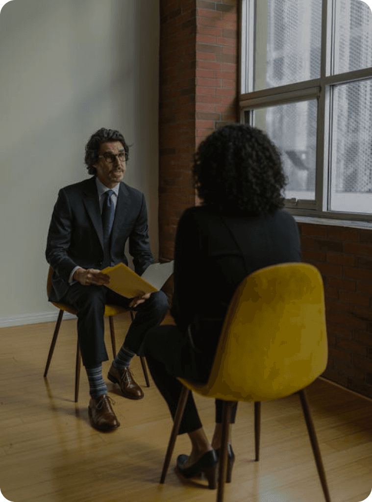 A man in suit facing a woman in a like interview session