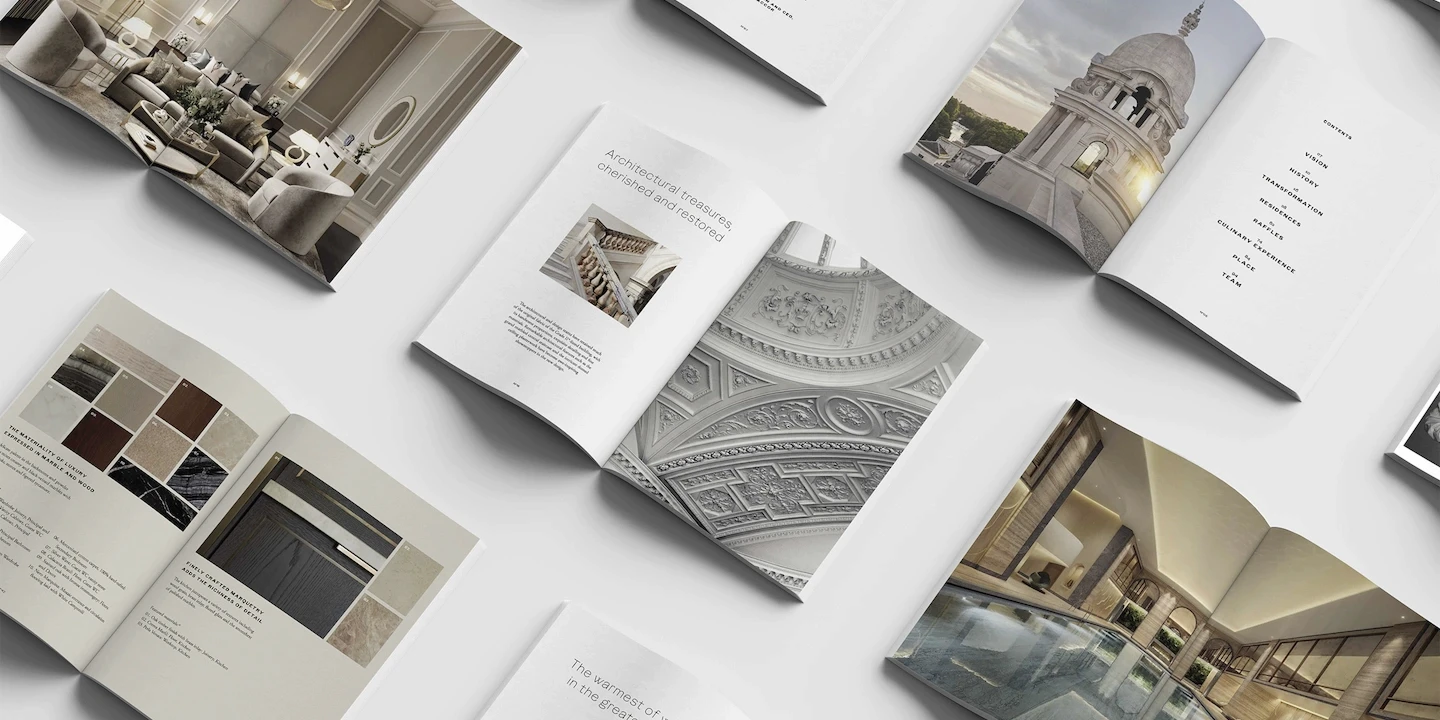 Multiple open brochures showing opulent interiors, pool facilities and architectural features of The OWO Residences.