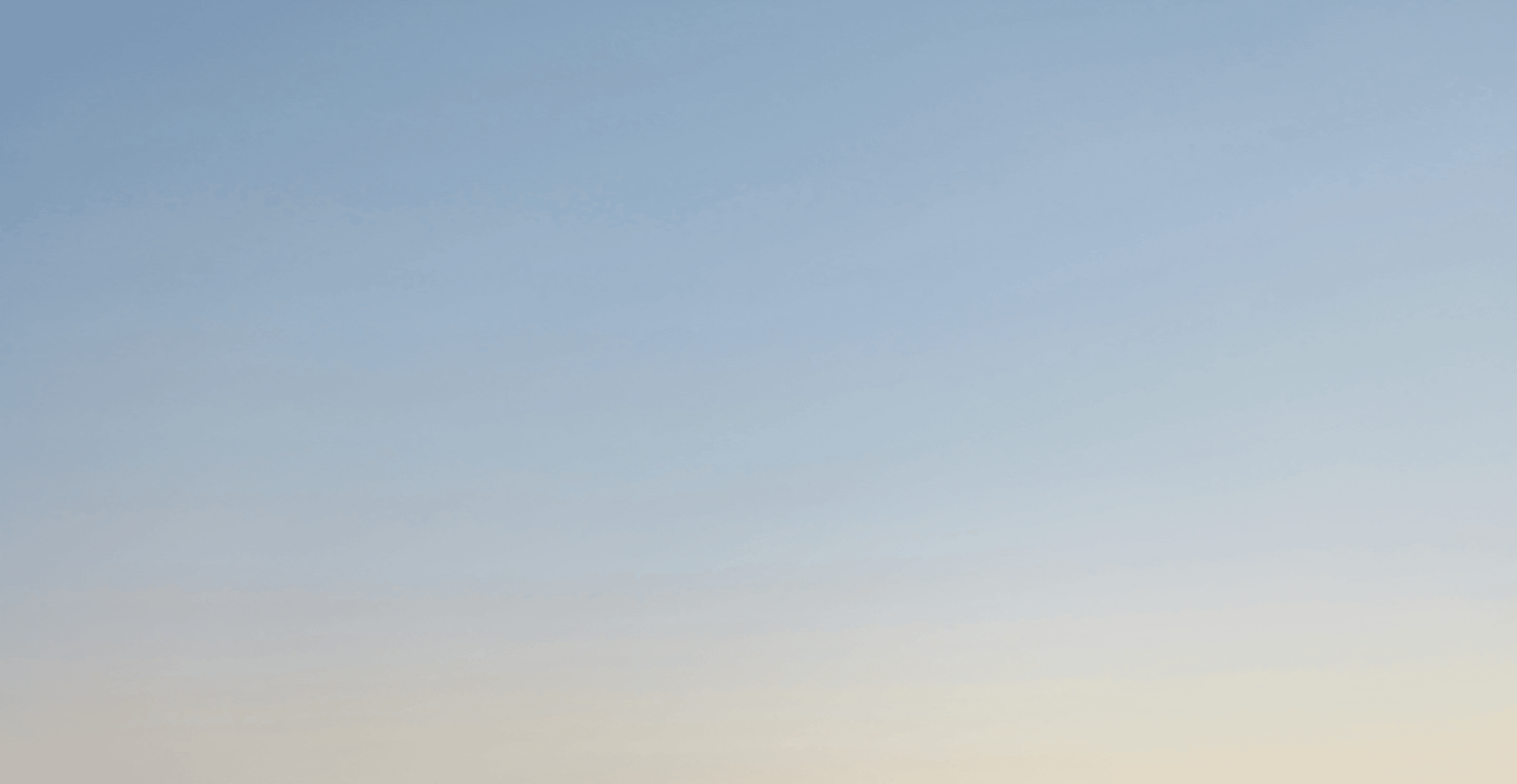 a plane flying in the sky at sunset