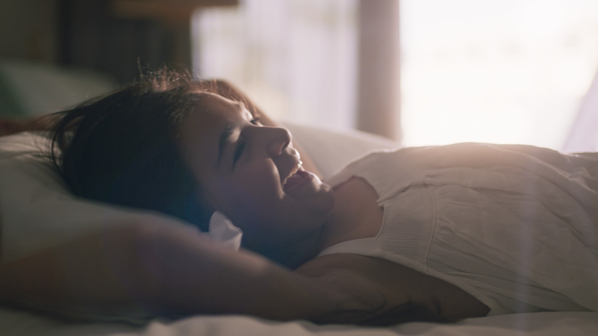 child in the bed with morning light