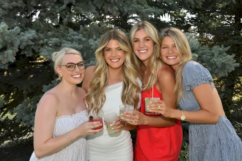 Girls posing and smiling with cocktails