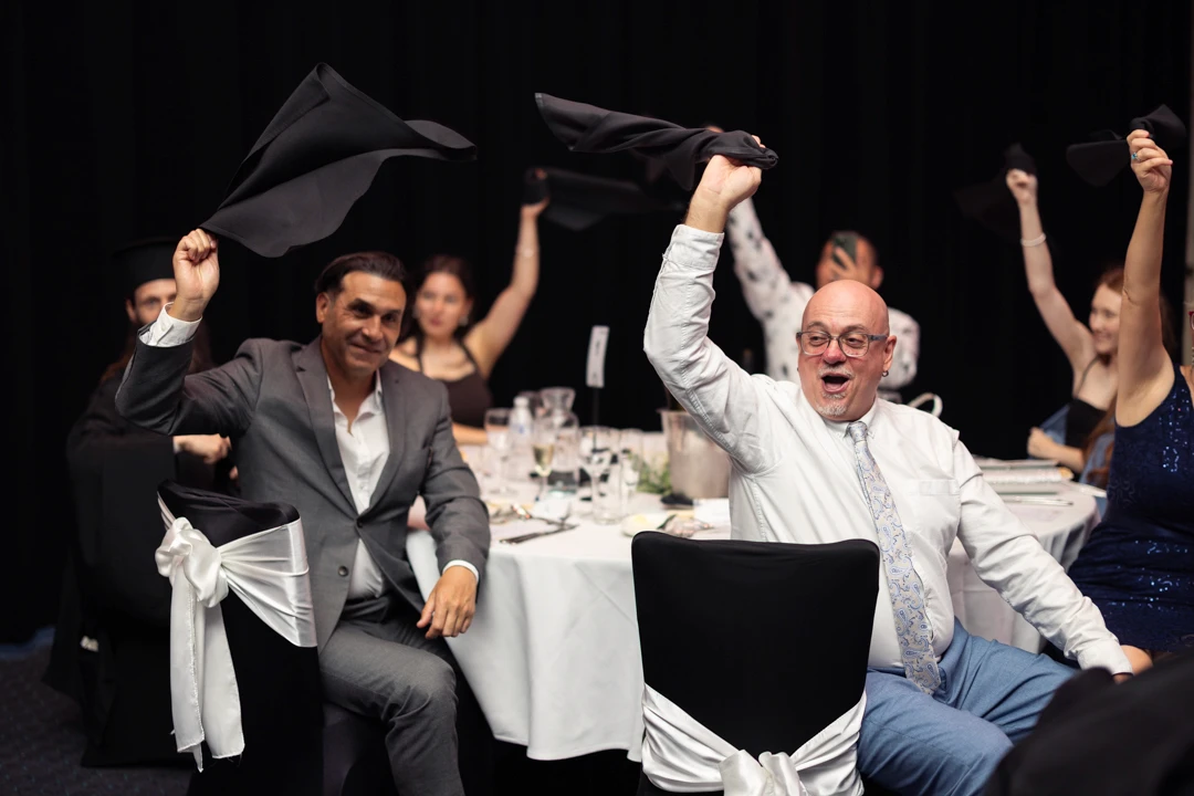 Guests waving napkins in the air at Greek wedding